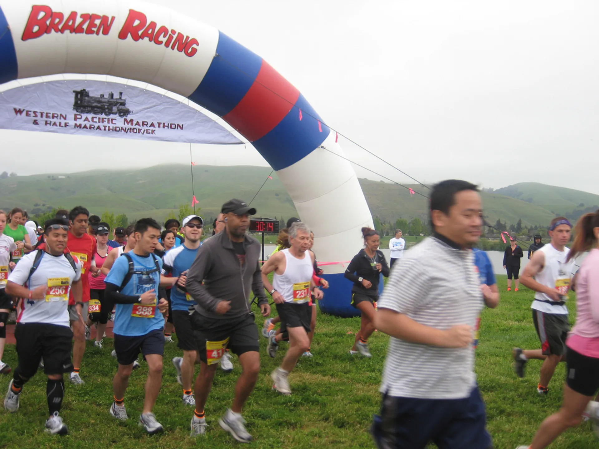 The image depicts a group of individuals participating in a running event. They are passing