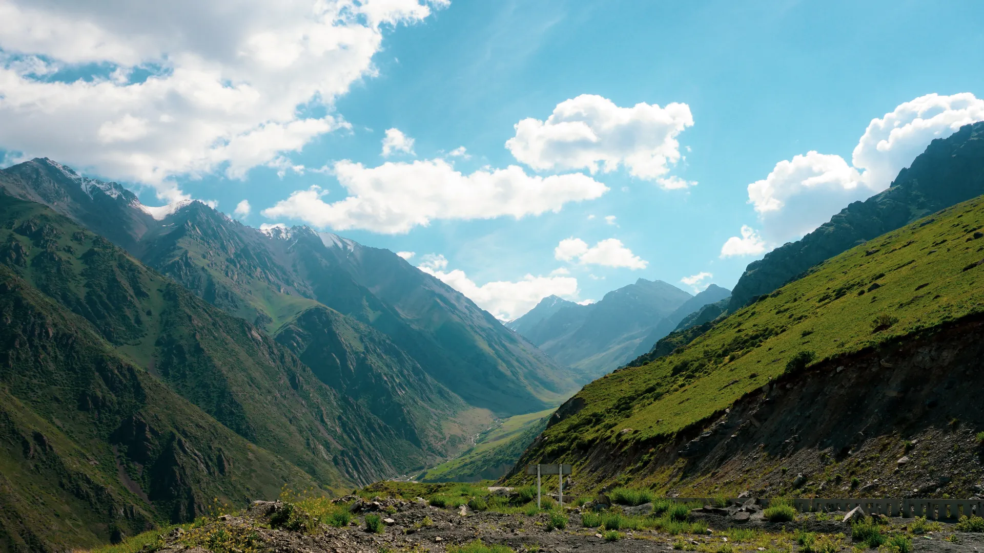 The image features a scenic view of a mountainous landscape under a blue sky pepper