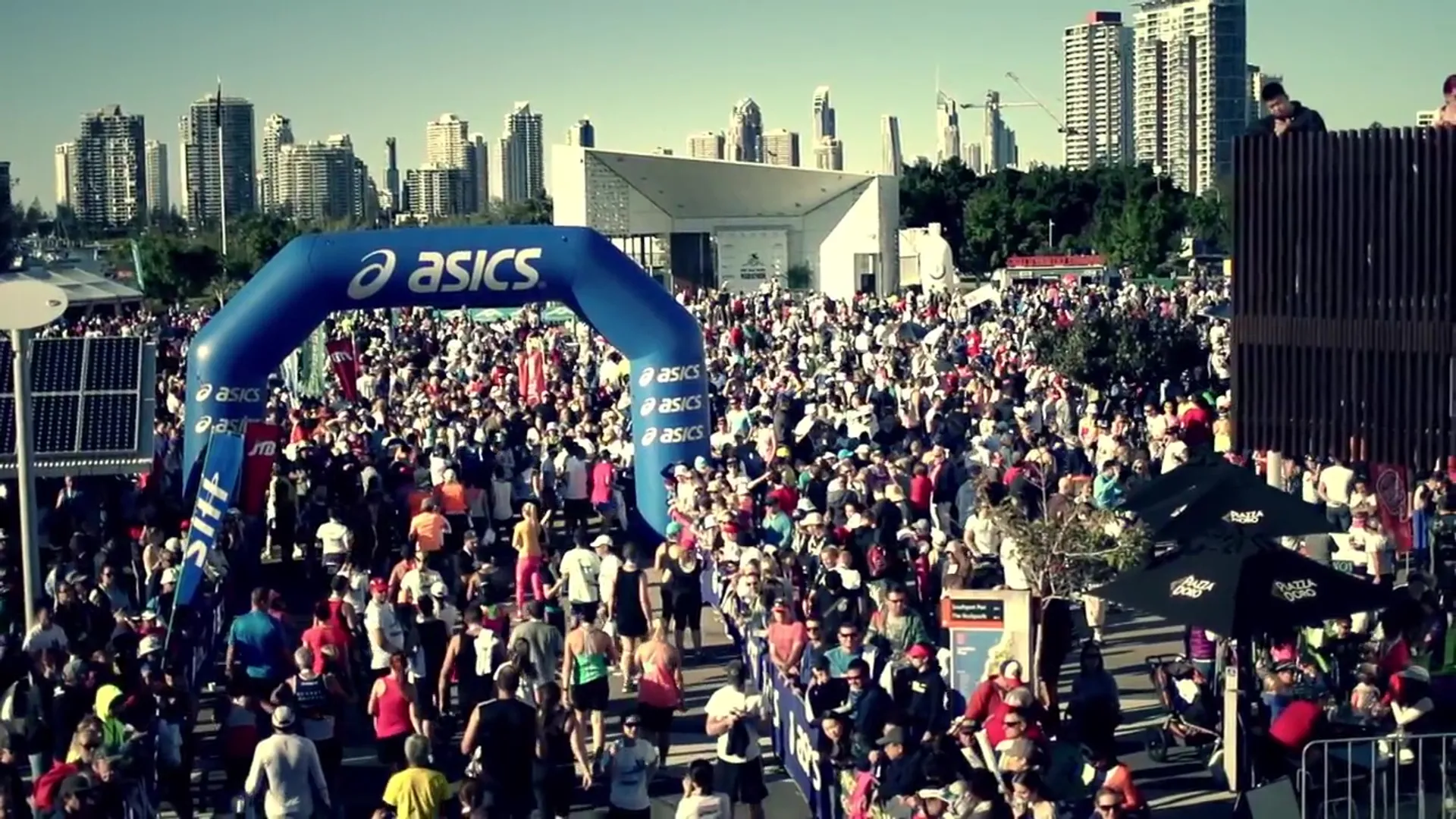 The image shows a crowded event with many people, likely at a running race or