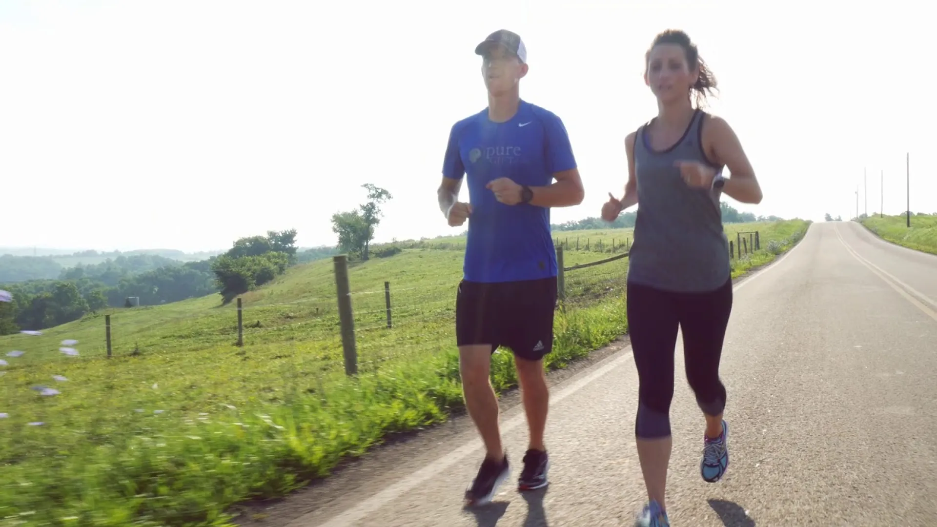 The image shows two people, a man and a woman, jogging together outdoors during