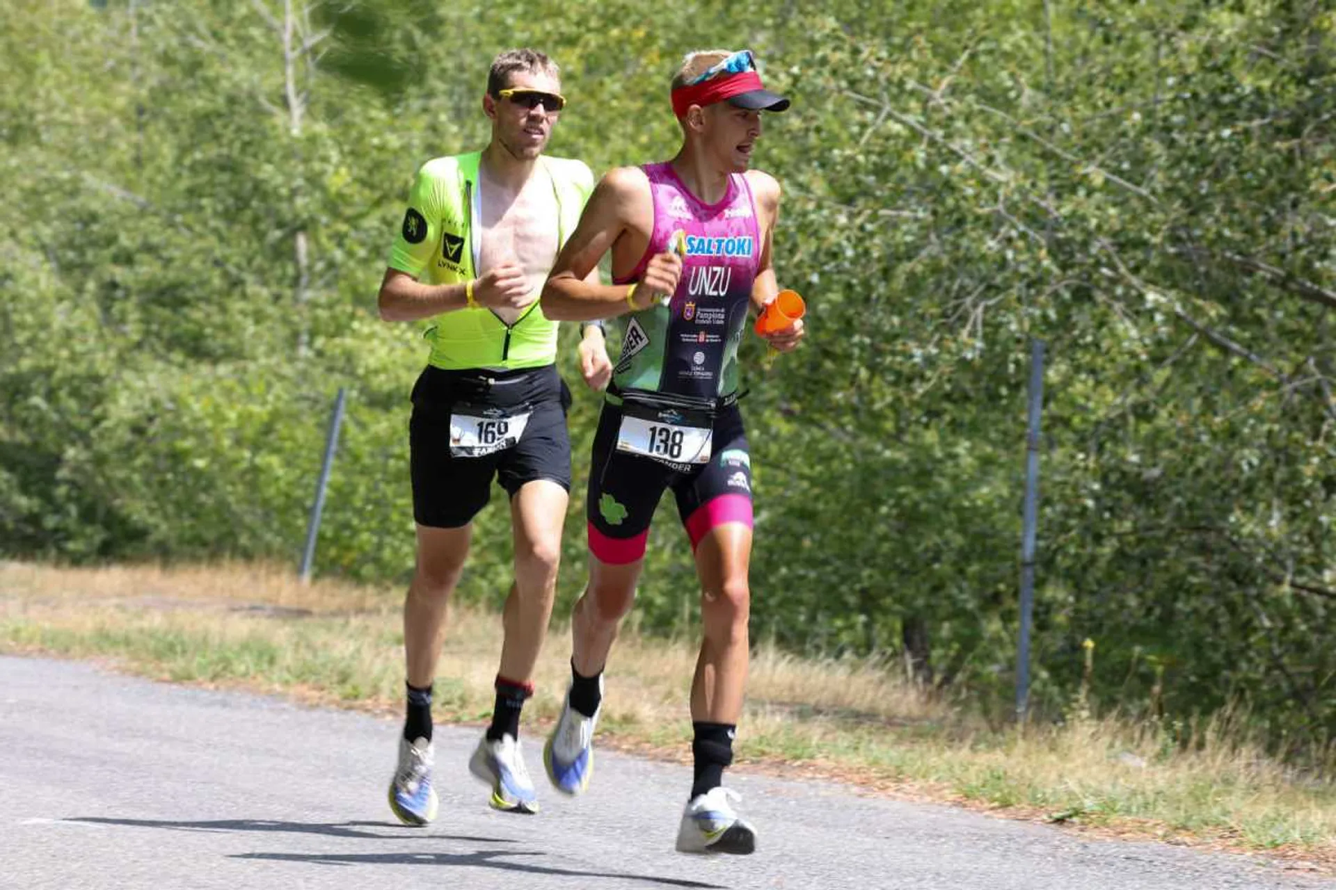 The image shows two athletes engaged in a running event, likely a part of a