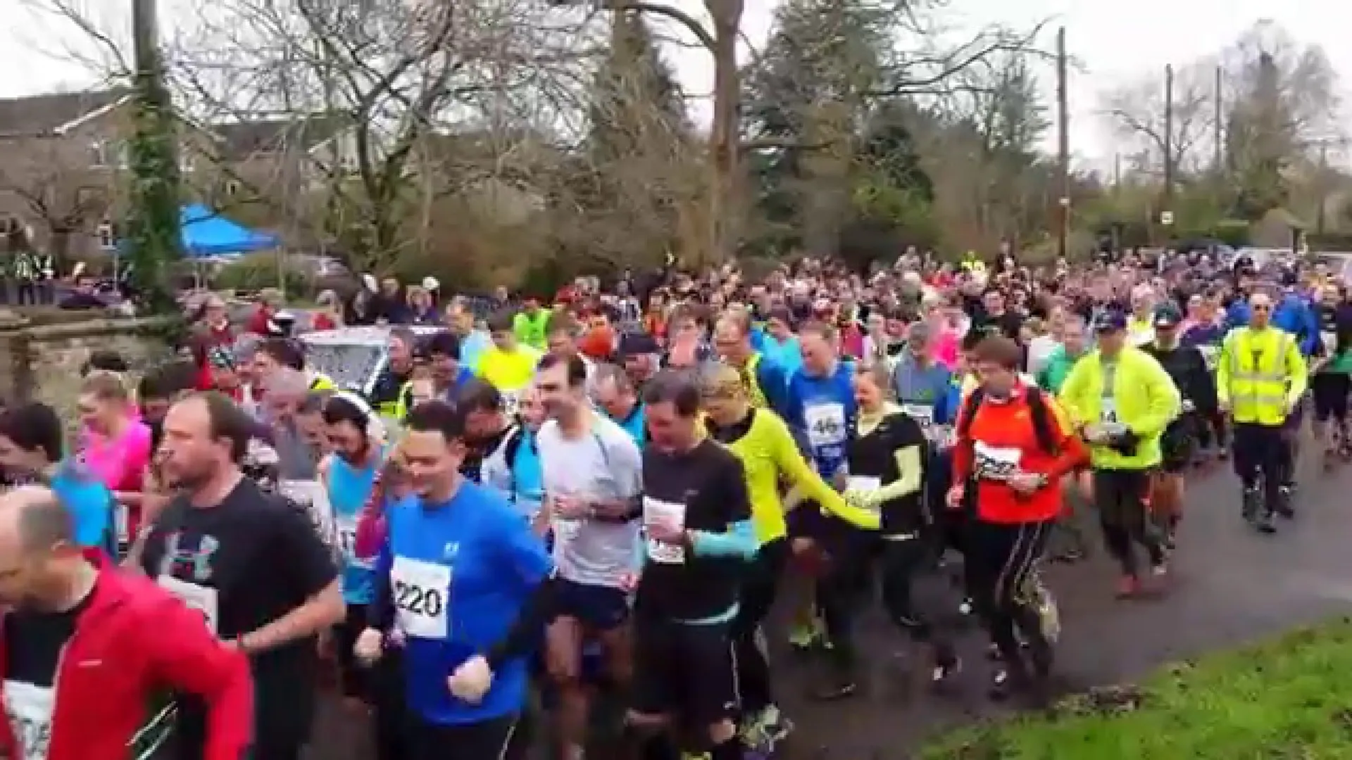 The image shows a group of people participating in a running event. They are dressed