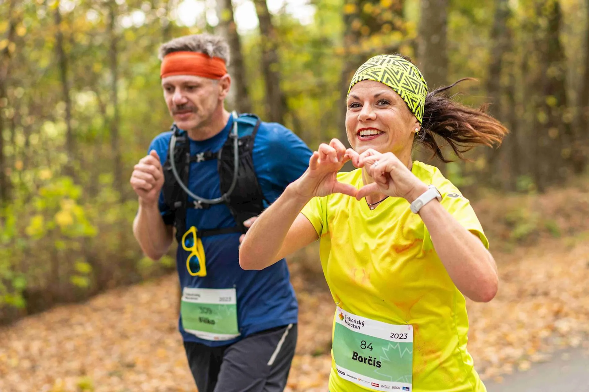 The image shows two individuals participating in a running event, likely a race or marathon
