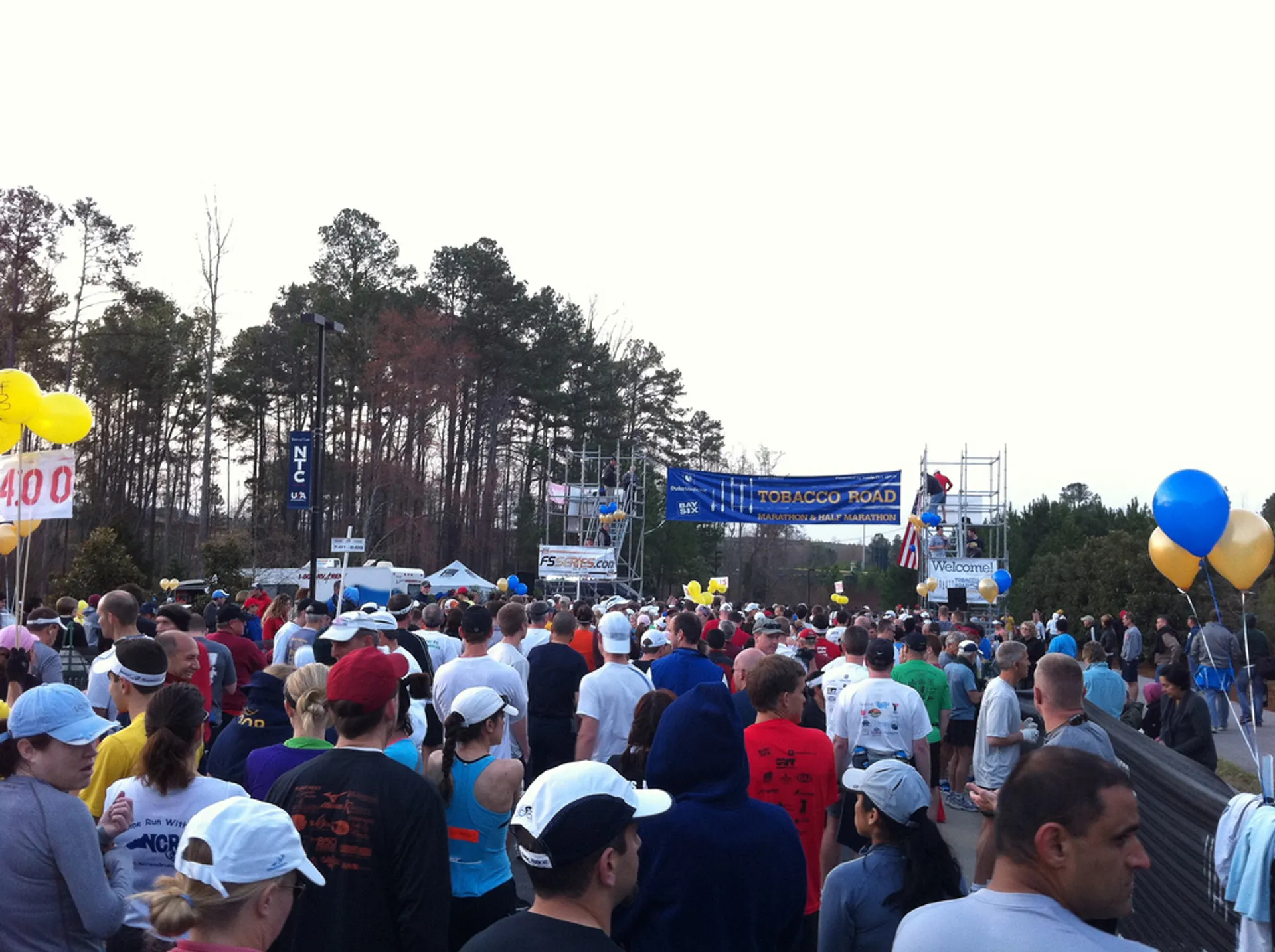 The image shows a large gathering of people, most likely participants at a running event