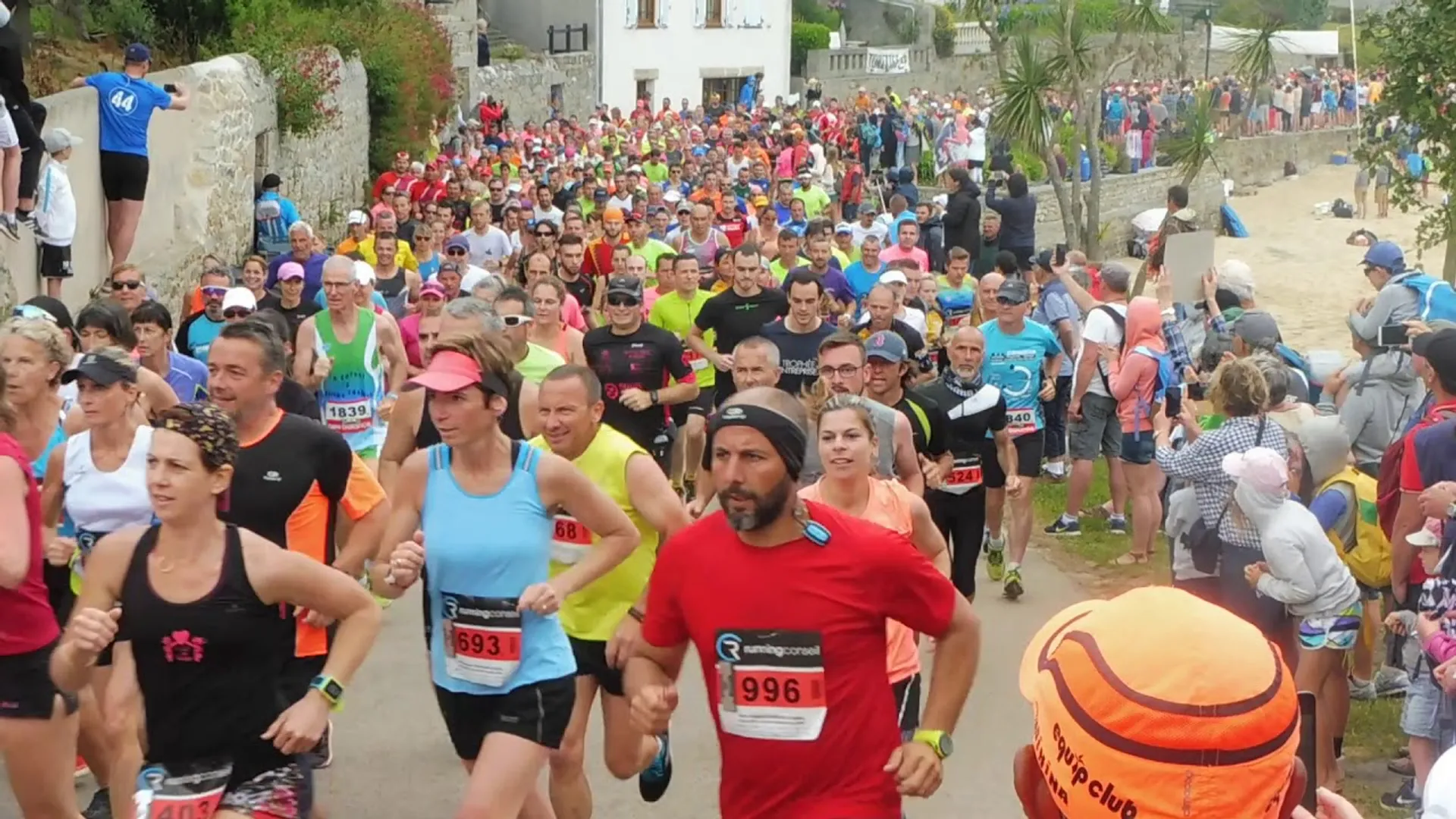 The image shows a large group of people participating in a running event. They are