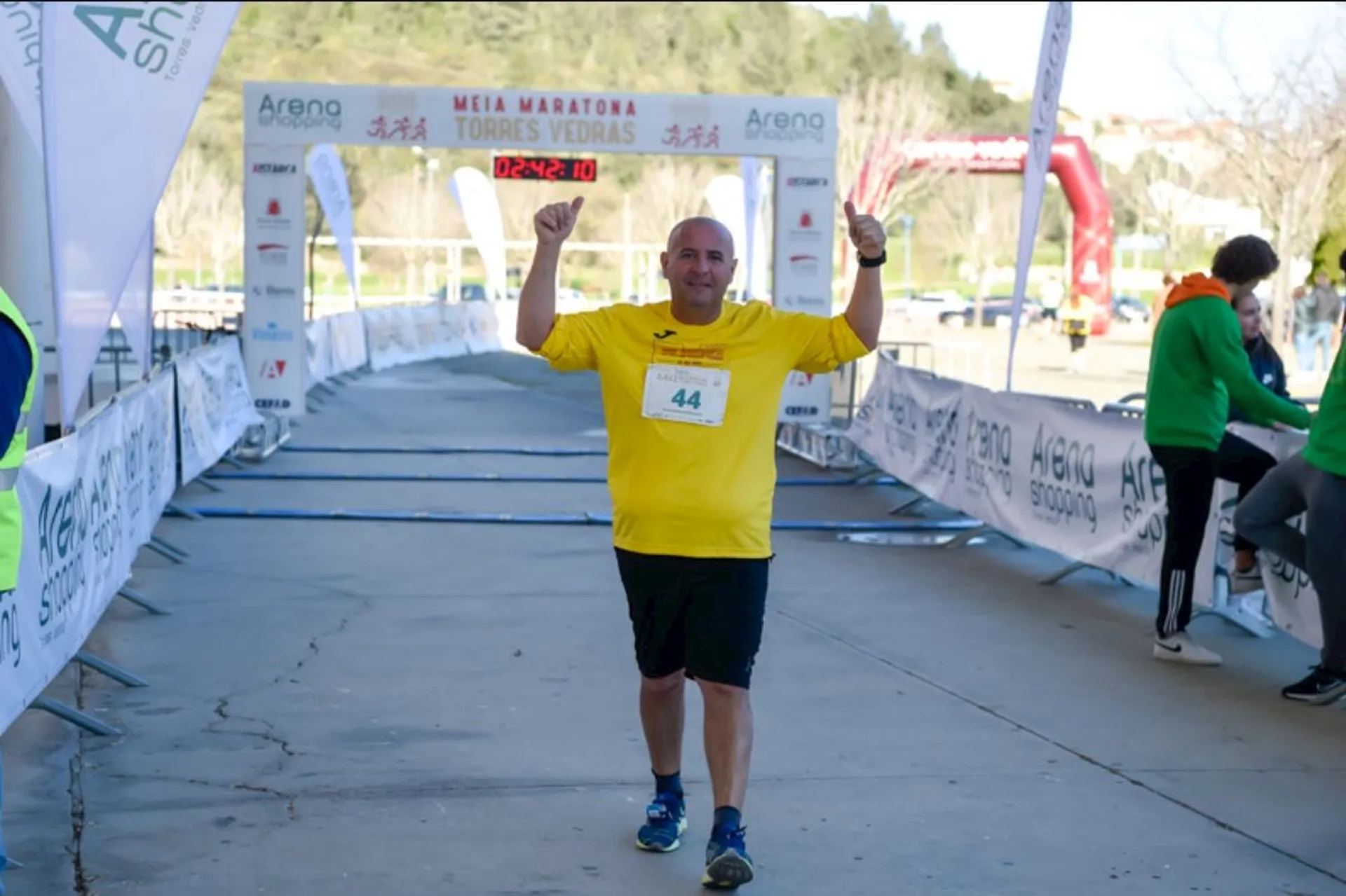 In the image, there is a person crossing the finish line of a running event