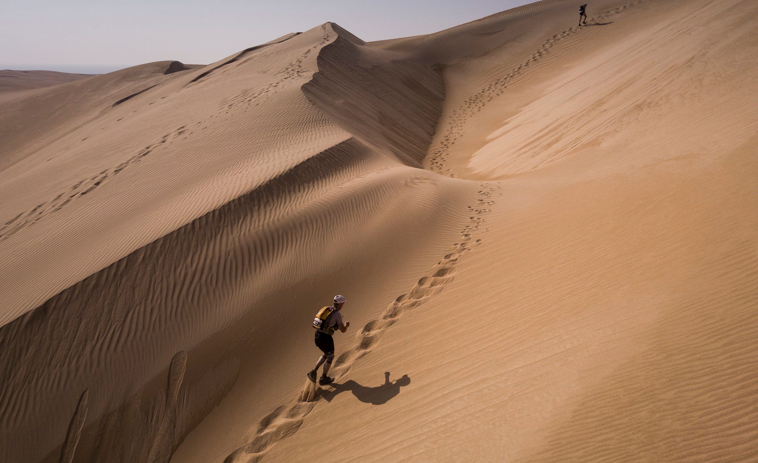 330ft Sand dunes tower above runners on the Oman Desert Marathon course