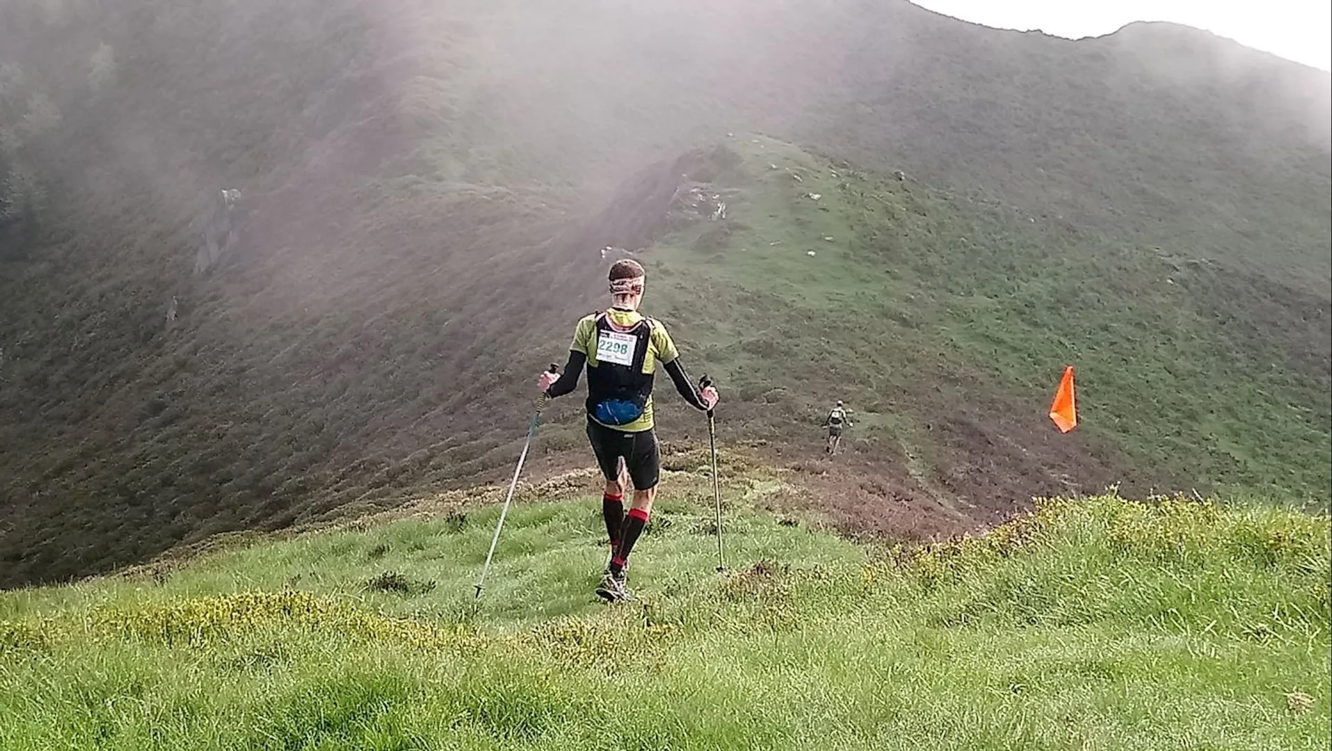 The image shows a person participating in an outdoor trail running event. The individual is