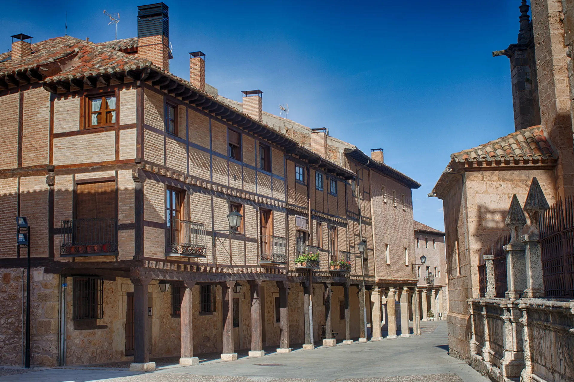 The image depicts a charming street scene characterized by traditional architecture, likely in a European