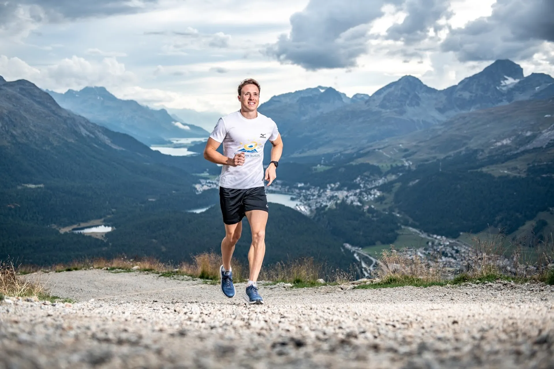 The image shows a person jogging or running towards the camera on a dirt path.