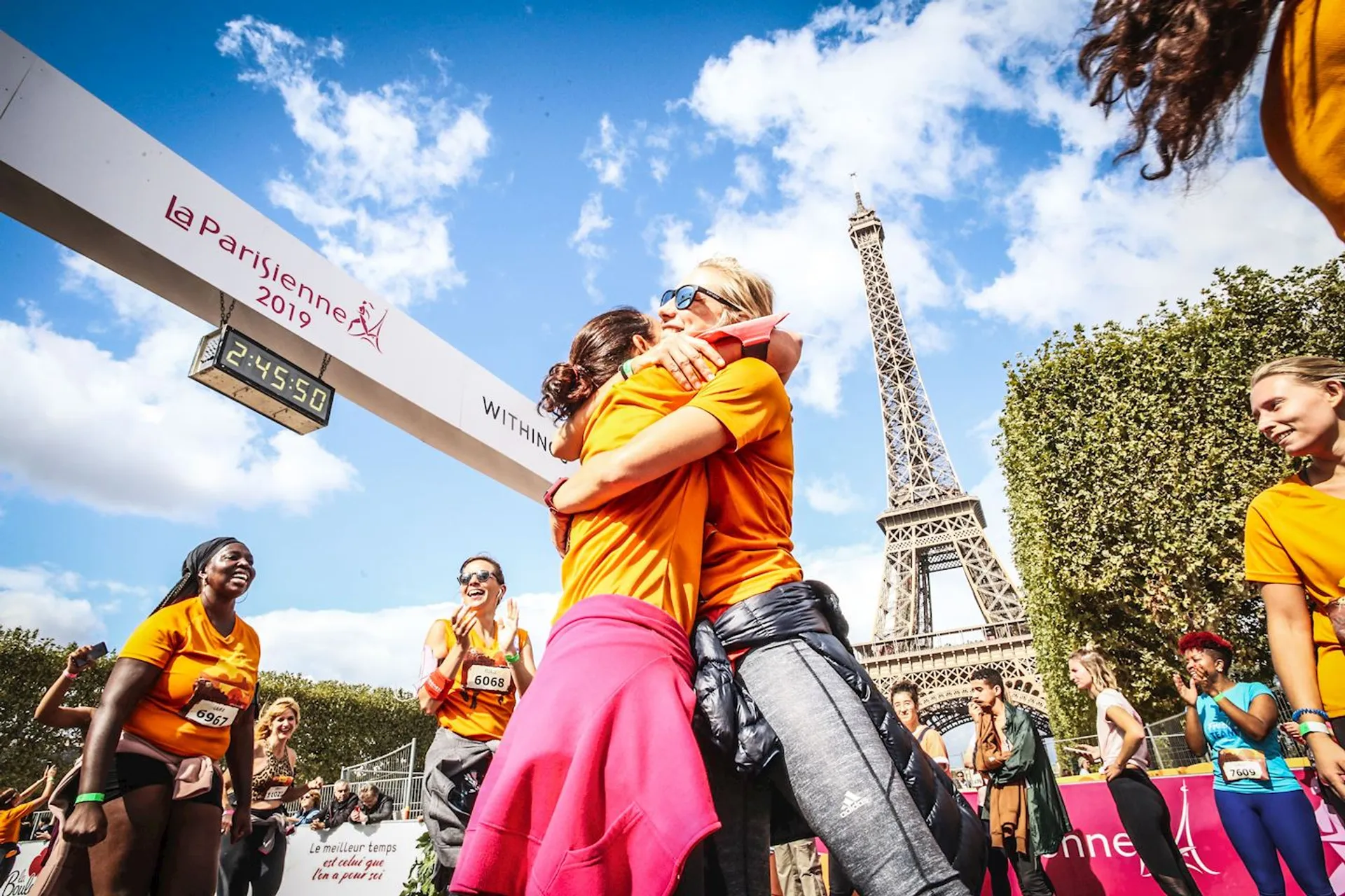The image features a joyful scene at what appears to be the end of a race