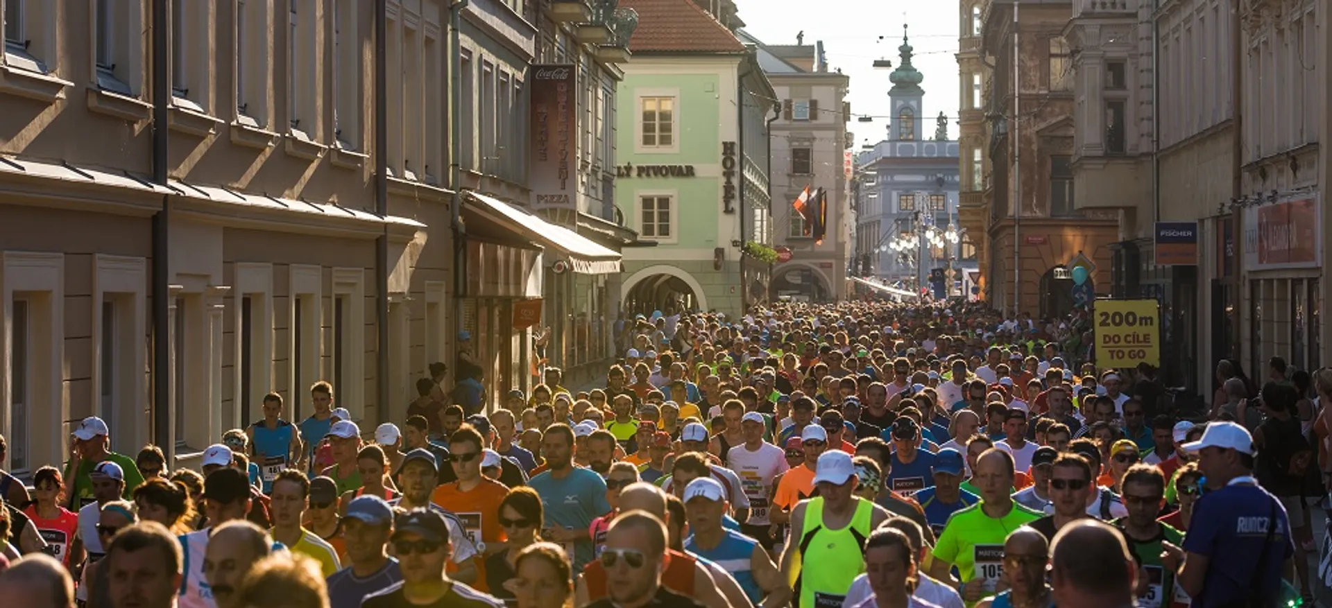 The image shows a large crowd of people participating in what appears to be a running