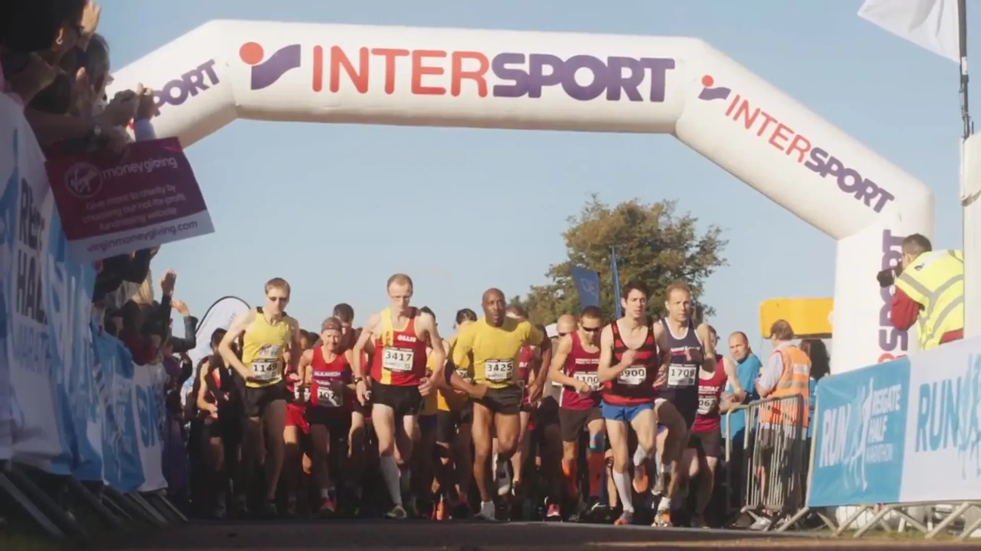 The image depicts a group of runners just as they are starting or passing through a