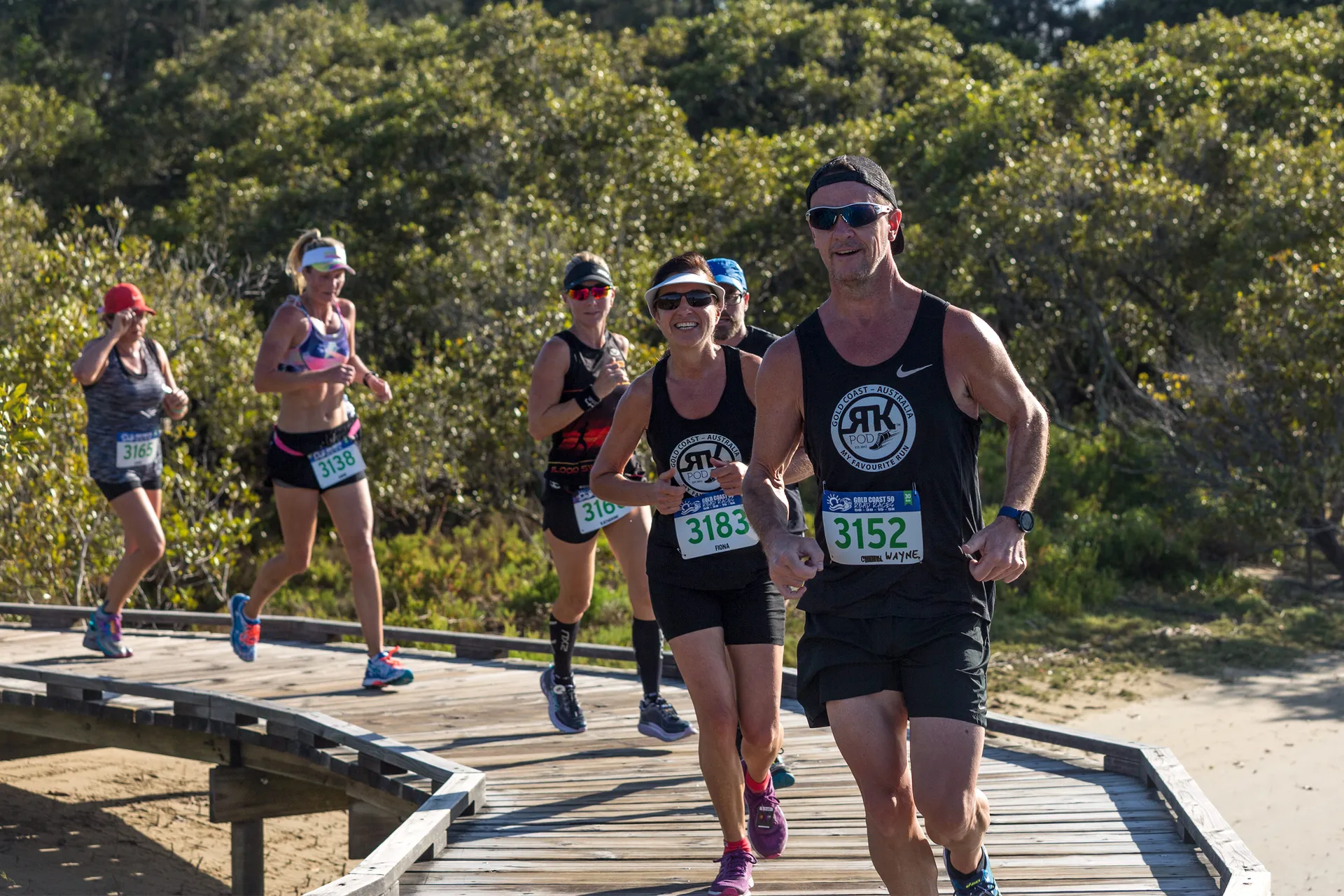 The image shows a group of runners participating in a race or running event. They