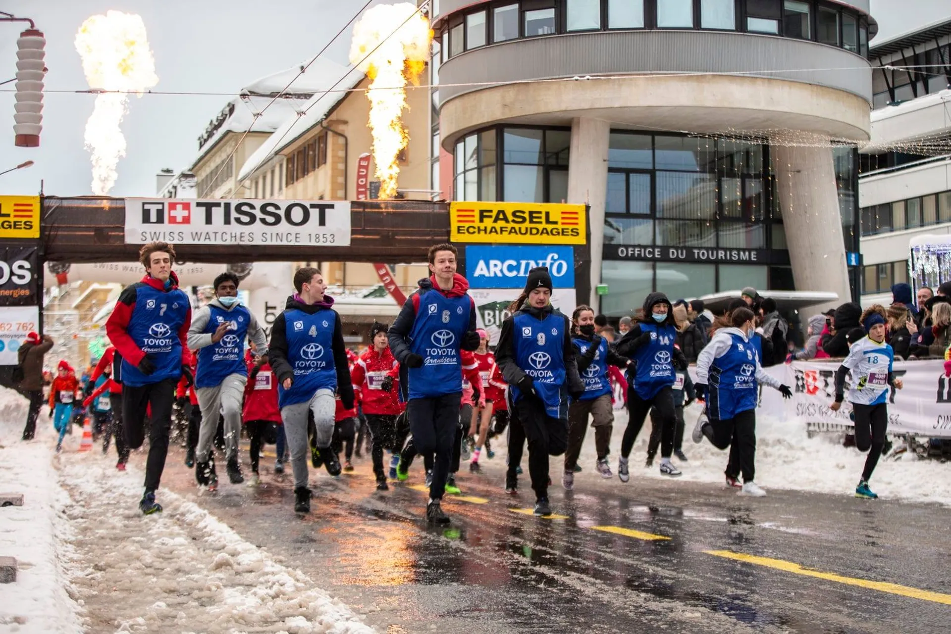 The image displays a group of people jogging or running on a snow-covered street,