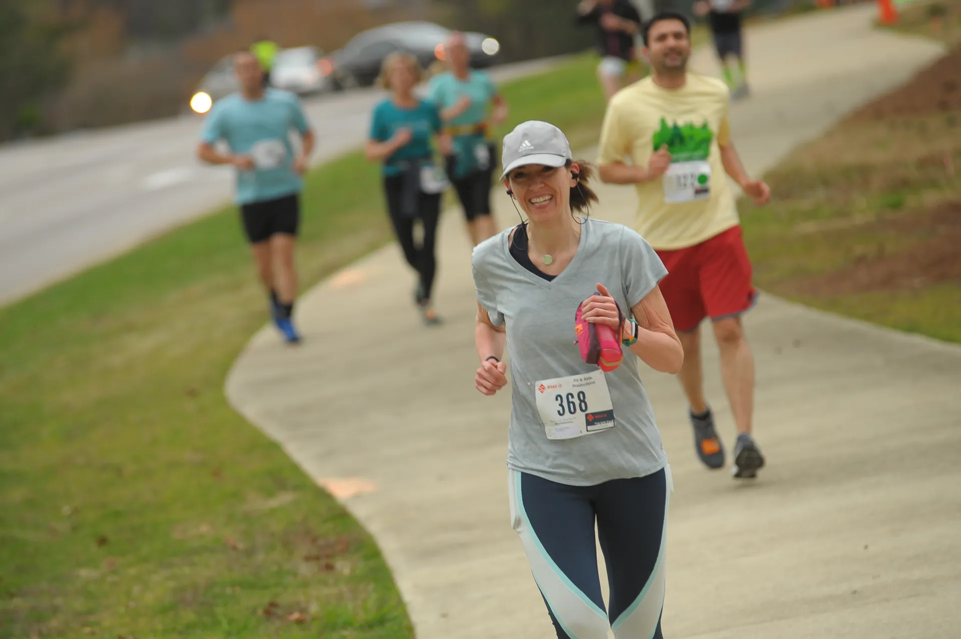 The image depicts a group of people participating in a running event. The focus is