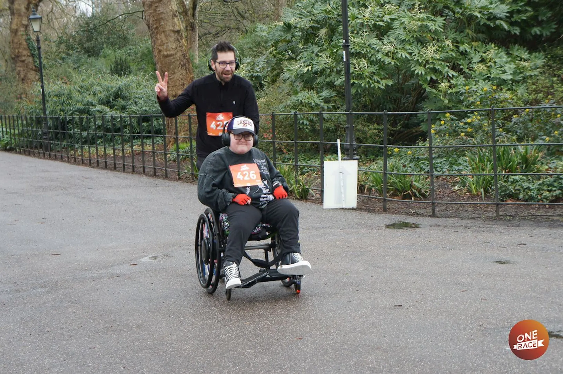 The image depicts two individuals participating in an outdoor event, likely a race or marathon