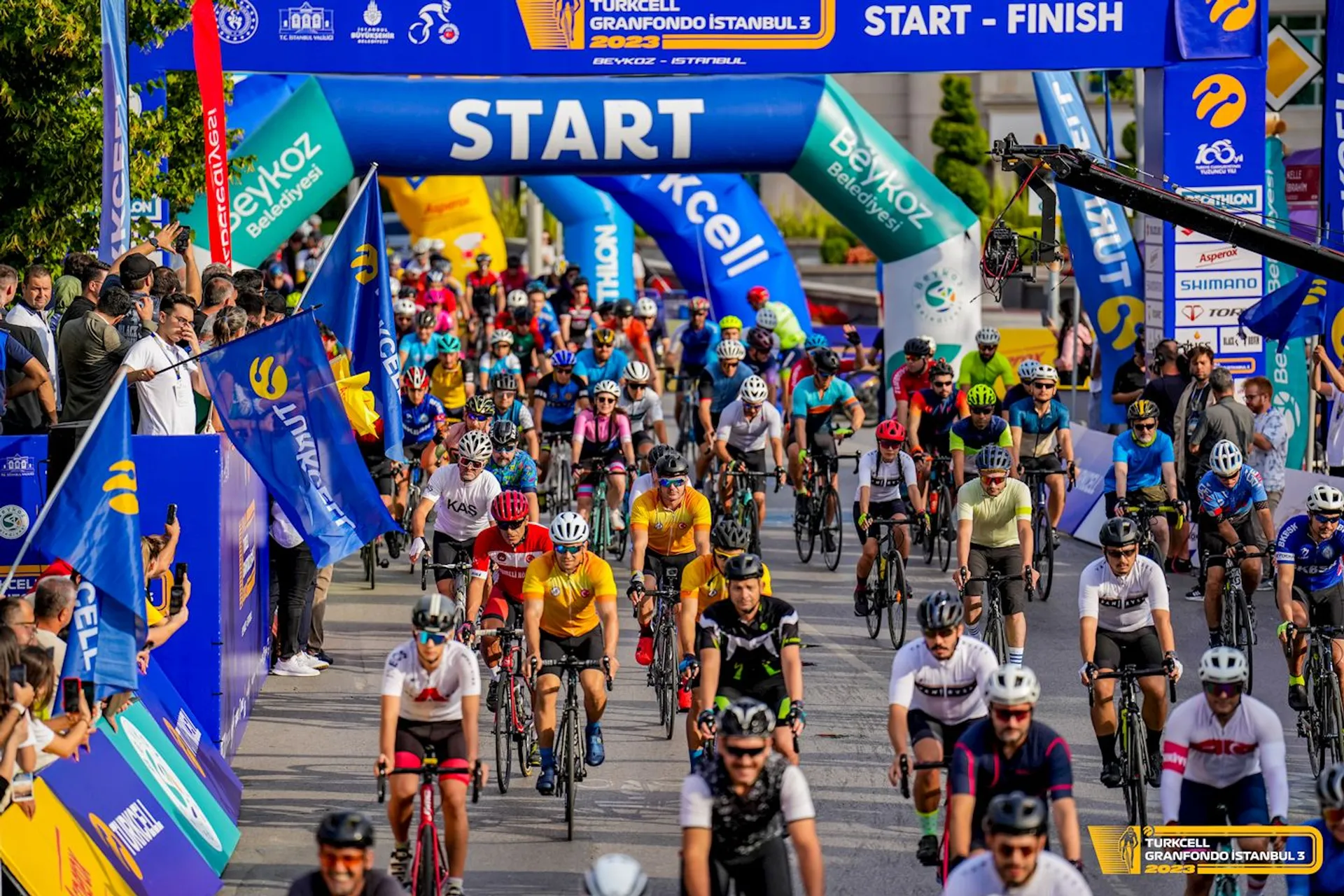 This image shows a large group of cyclists at the start of a cycling event,