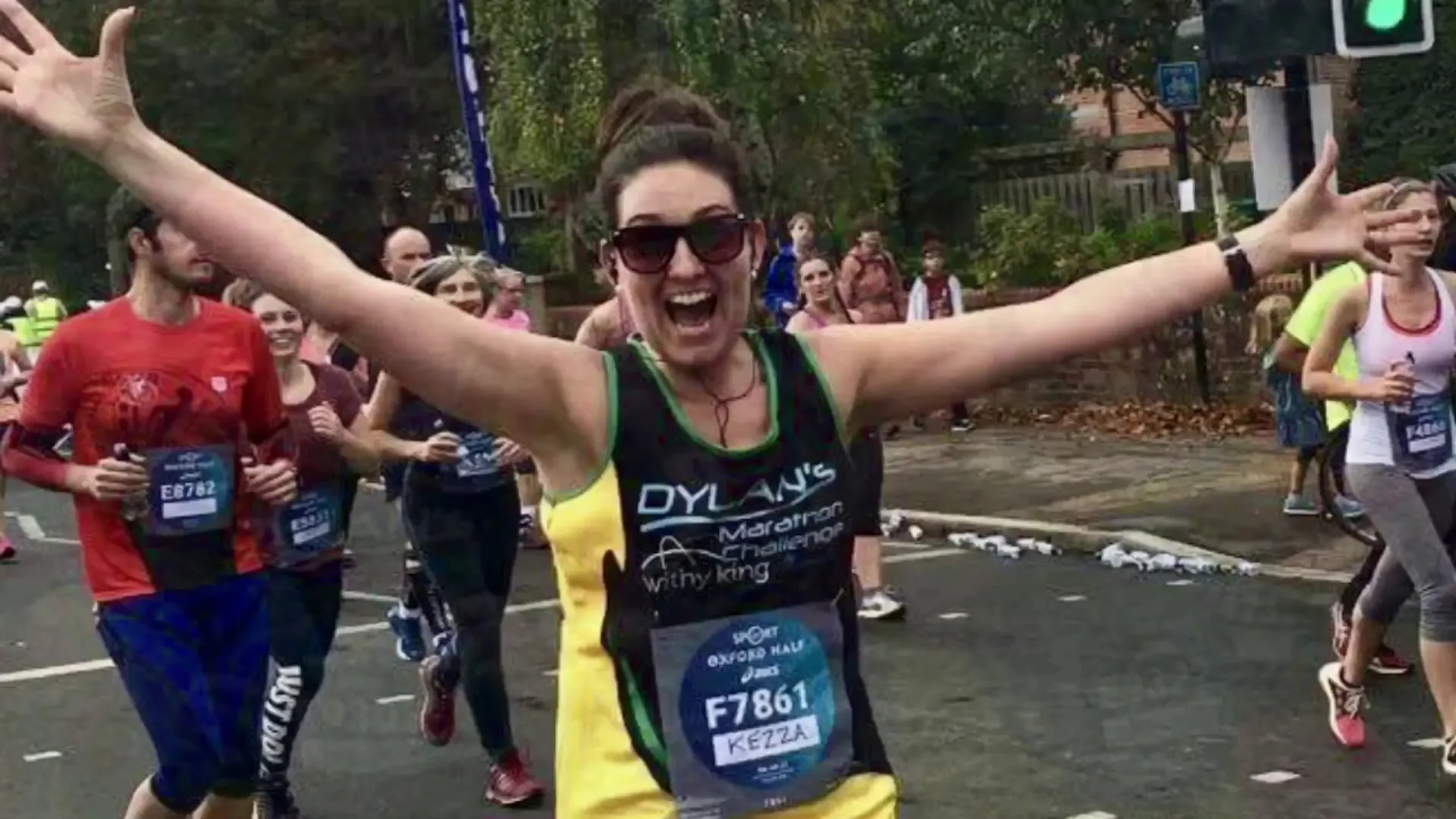 The image depicts a joyous moment at a marathon event. A woman is at