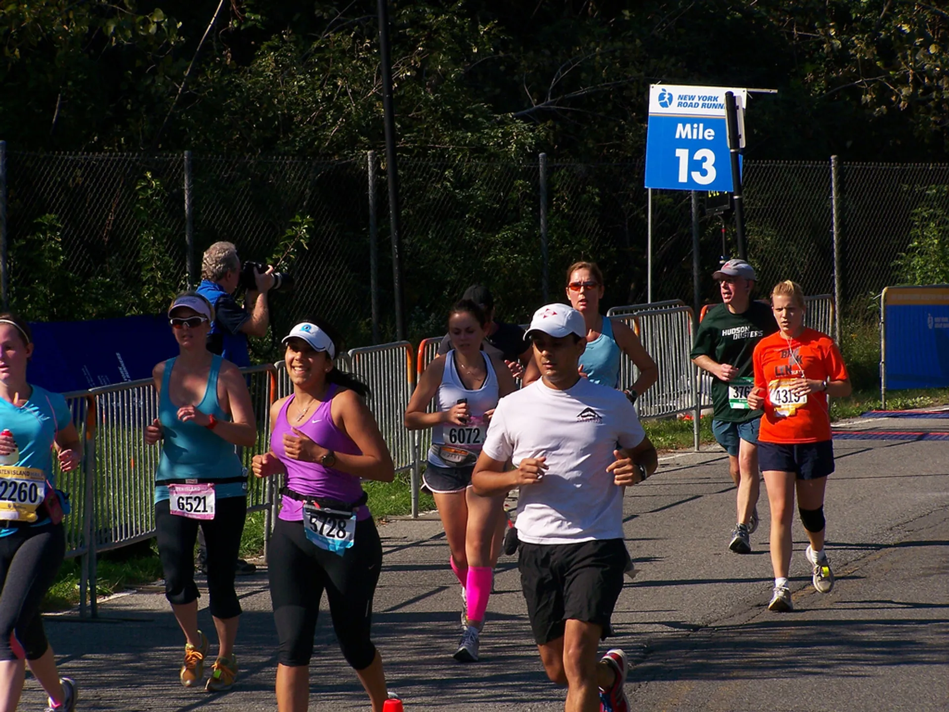 The image depicts a group of runners participating in a race, possibly a marathon or