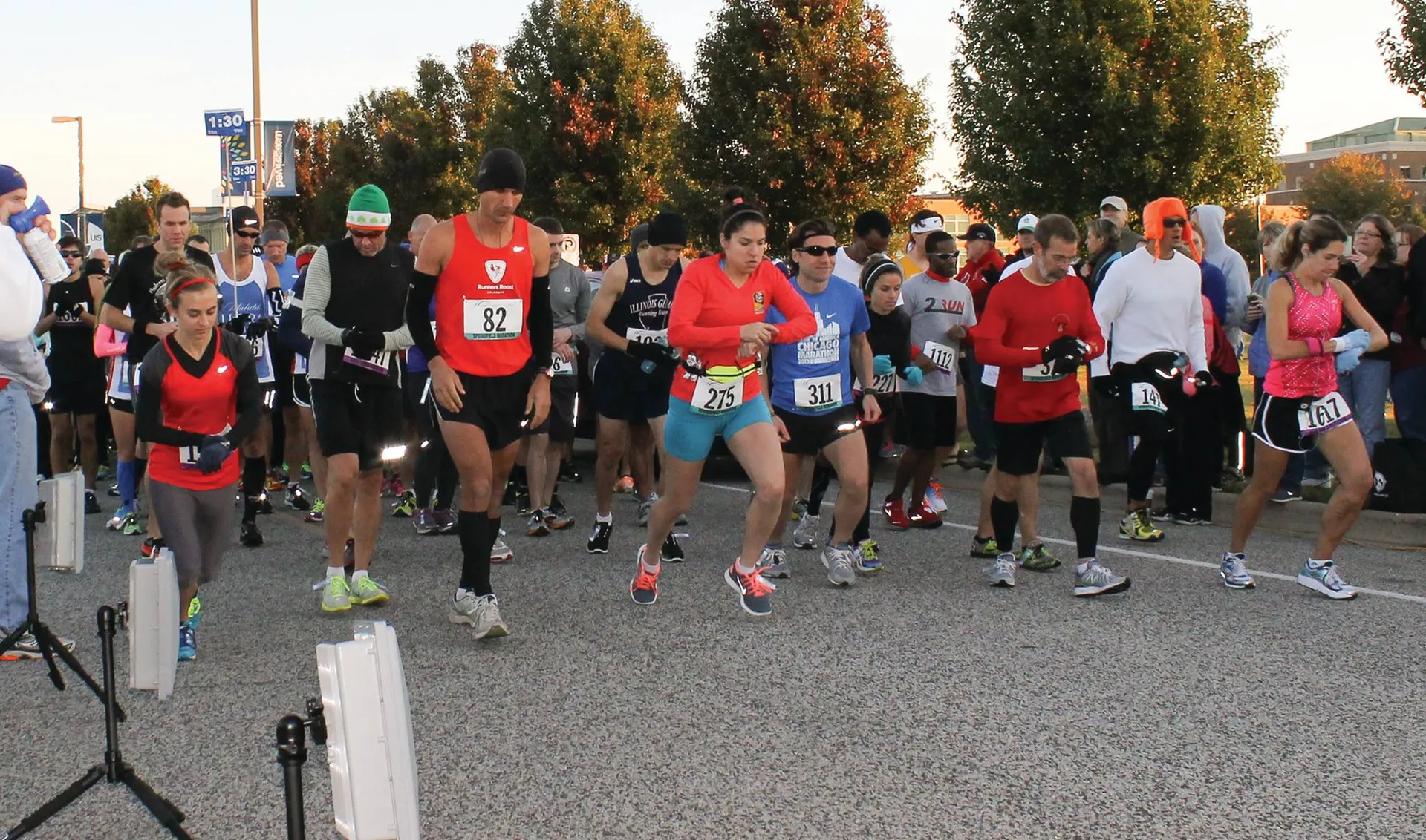 The image depicts a group of individuals participating in a running event, likely a race