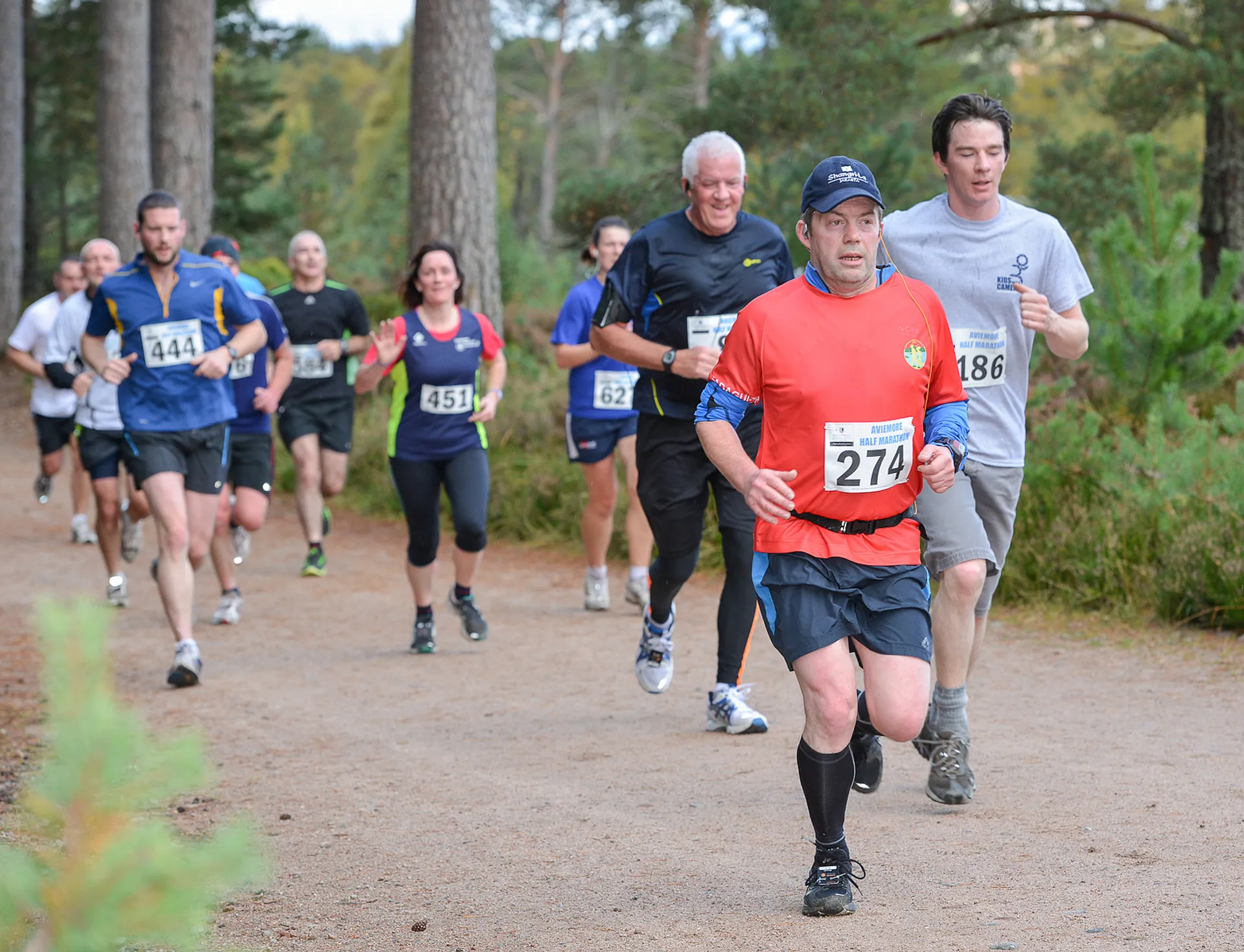 The image depicts a group of individuals participating in a running event or race. They
