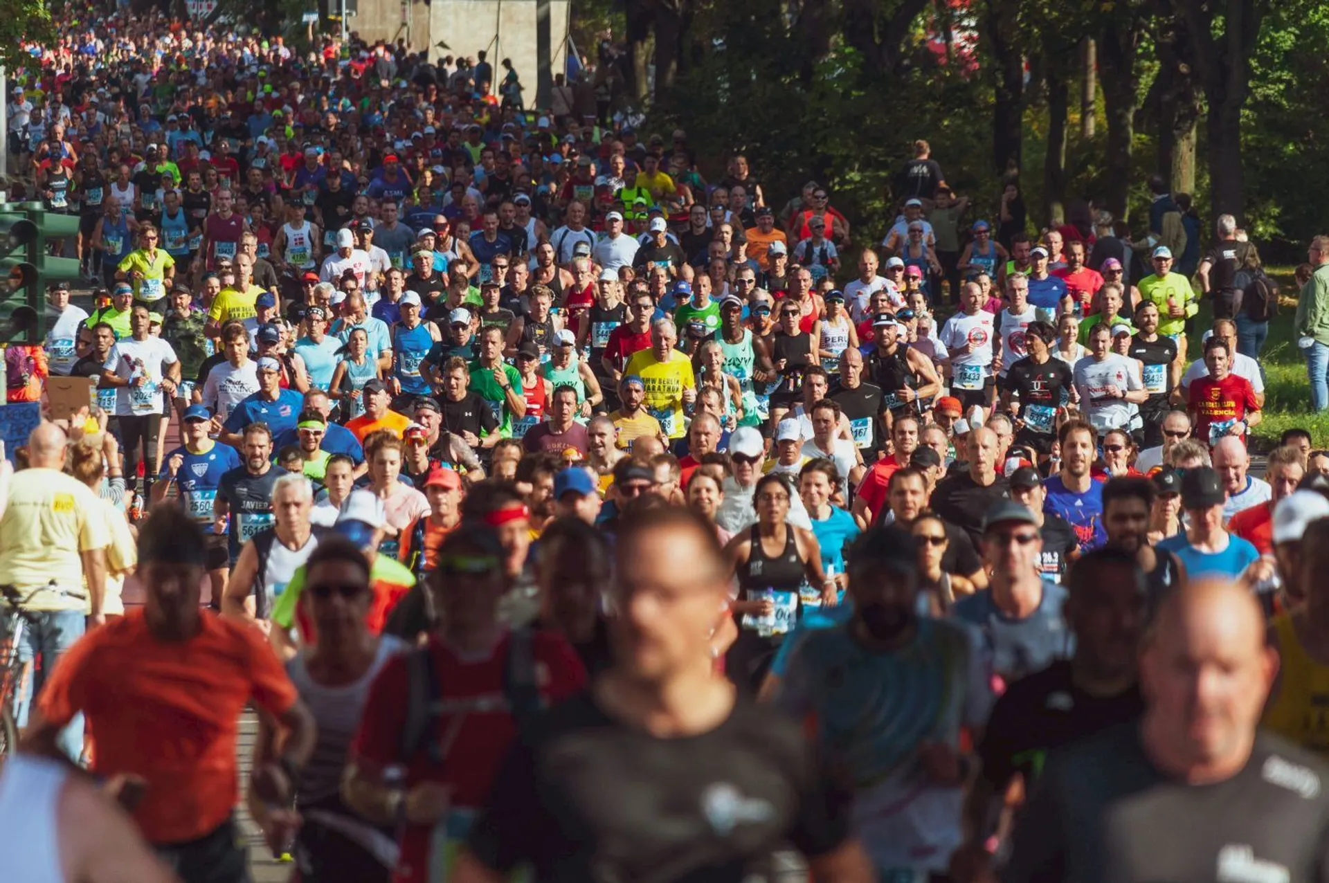 The image depicts a large group of people participating in a running event. It looks