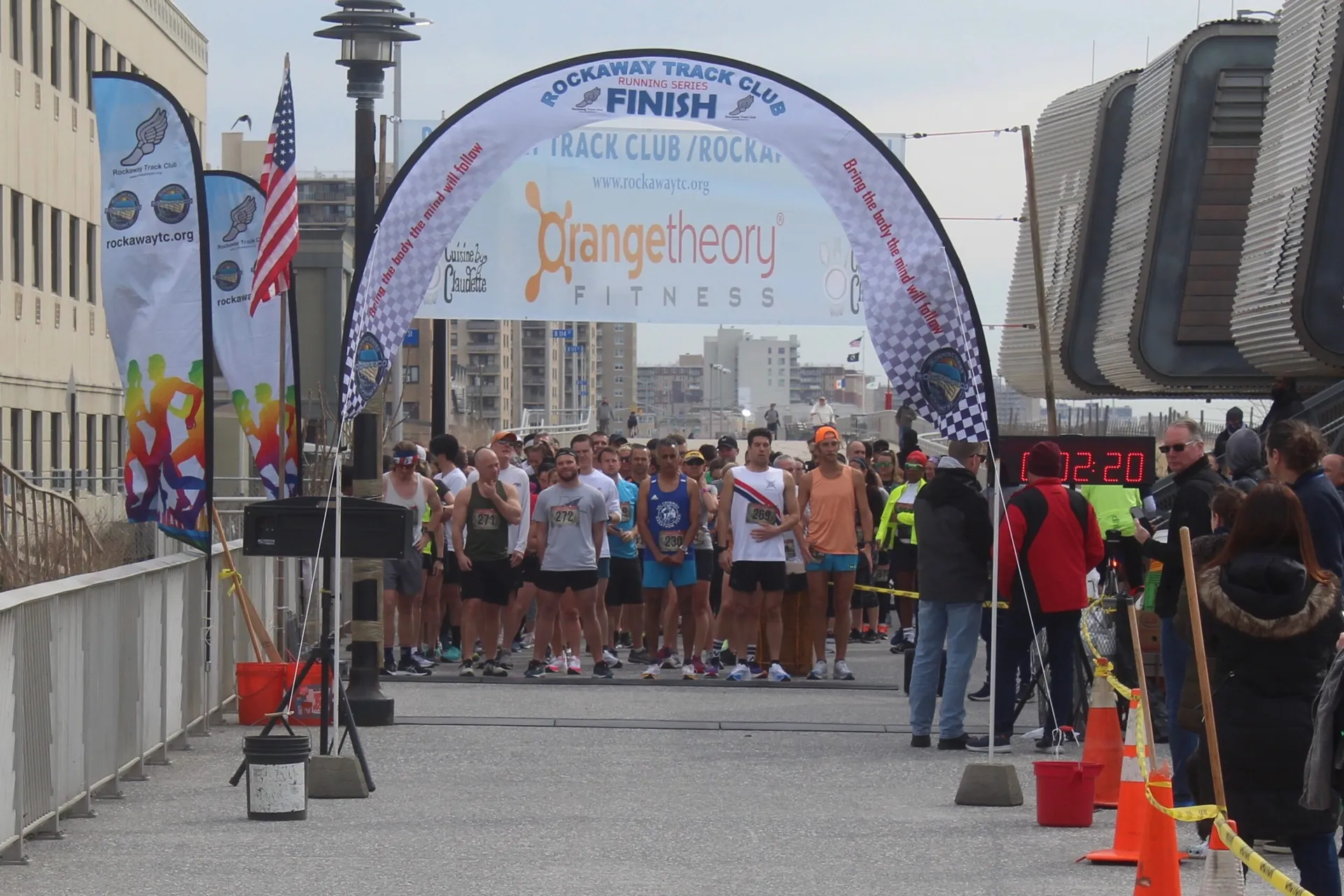 In the image, there is a group of runners gathered at the starting line of