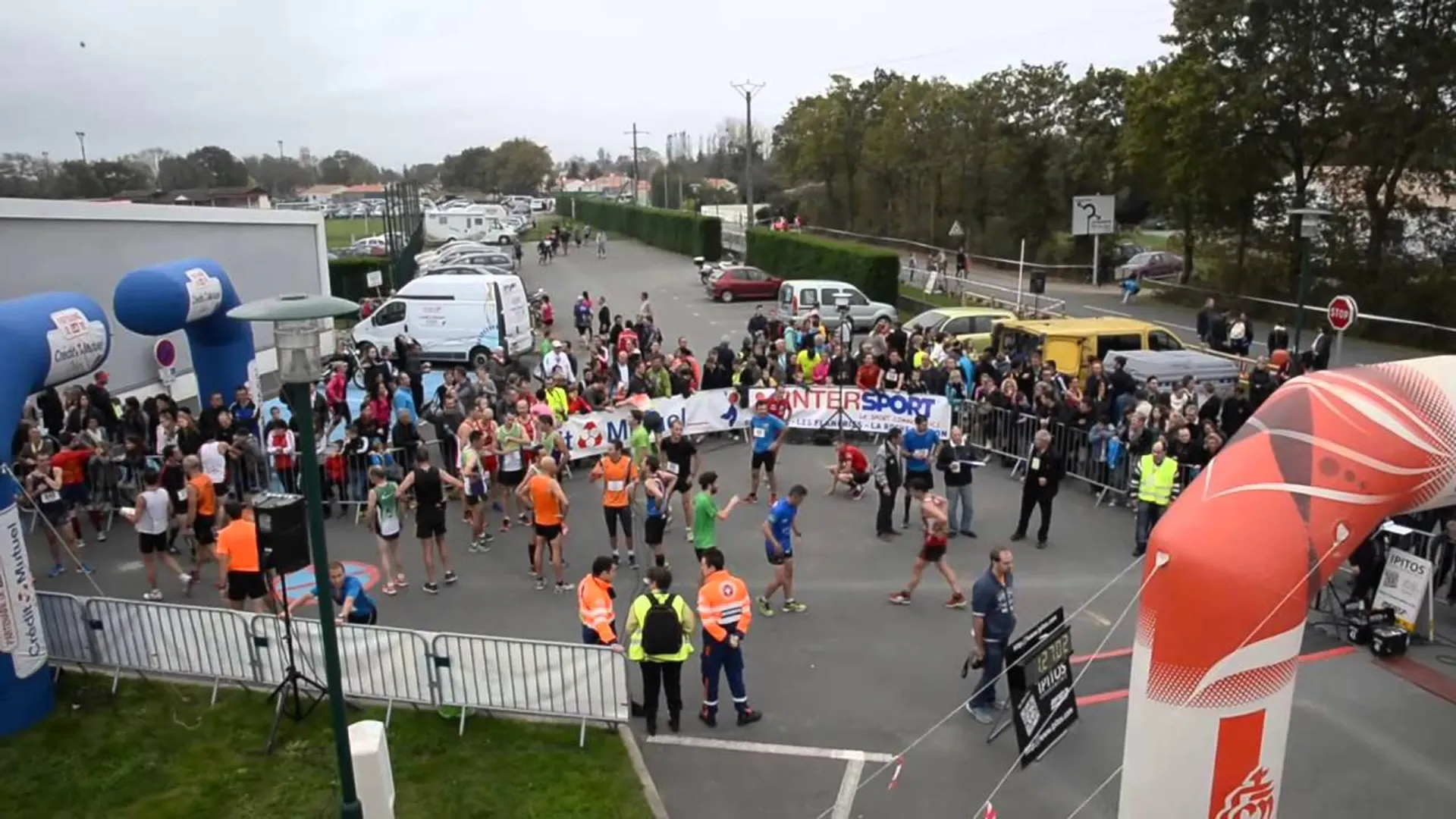 The image displays an outdoor event, specifically a running race or marathon, characterized by