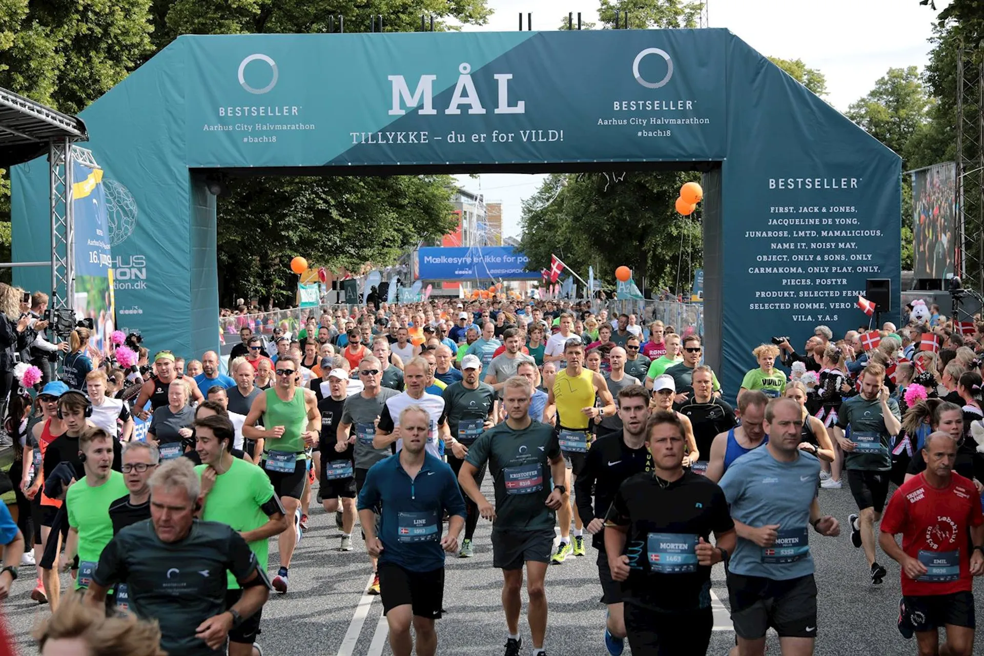 This image depicts a large group of runners participating in a road race. They appear