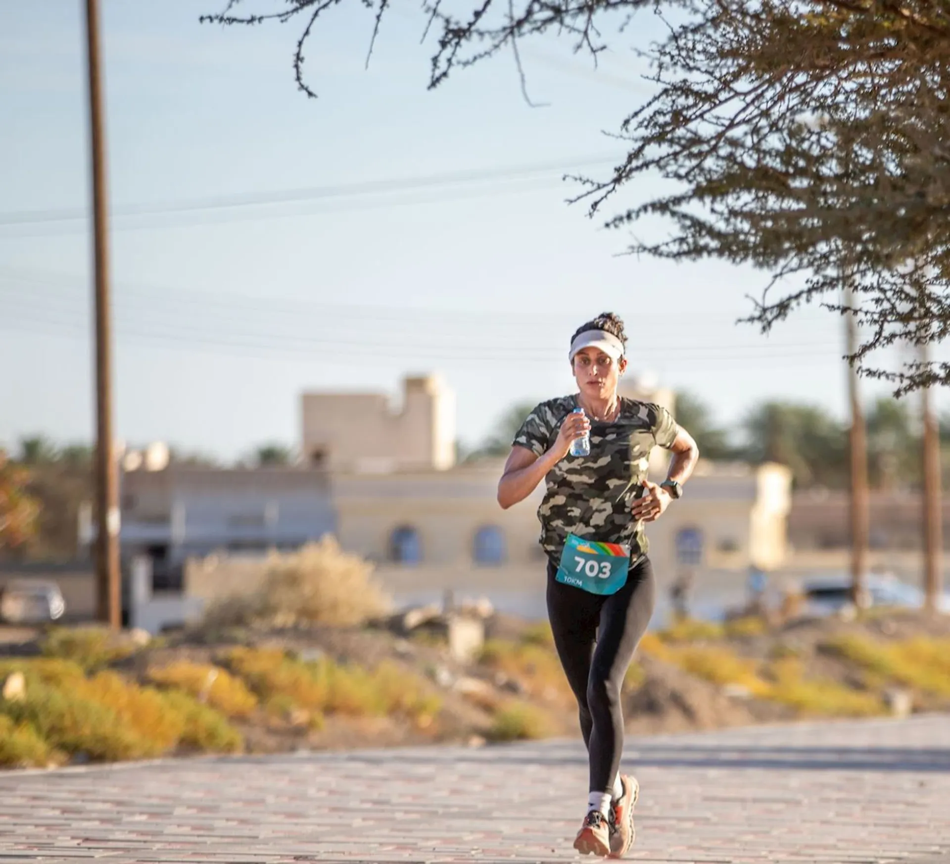 The image shows a person running in what looks like a road race or marathon setting