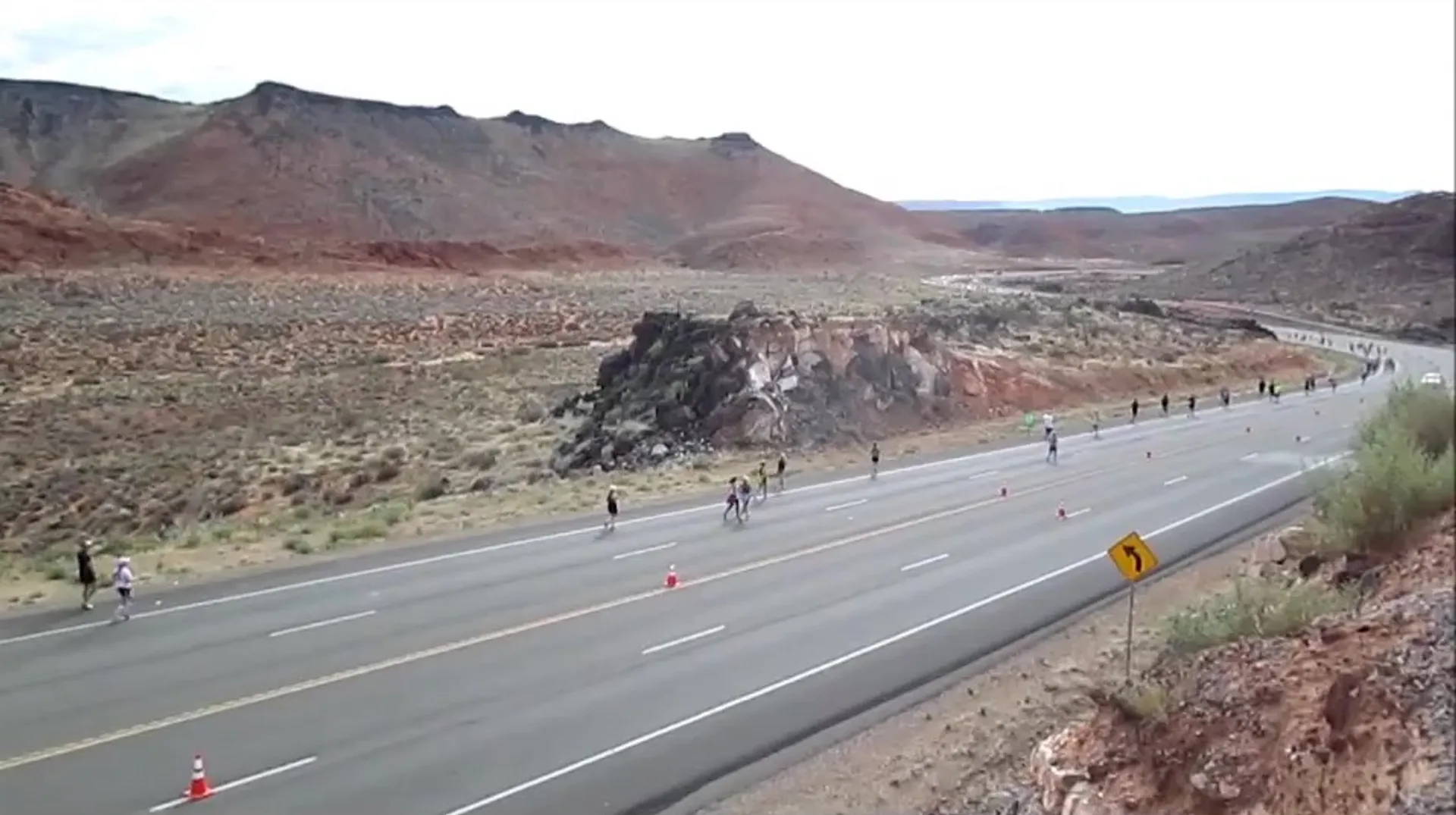 The image shows a group of runners participating in a road race. They are scattered