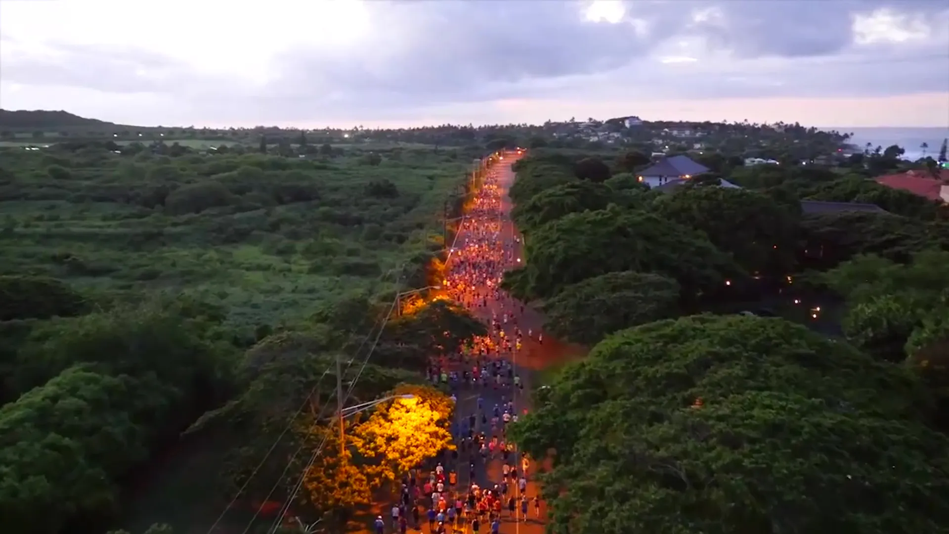 The image shows an aerial view of a large gathering of people participating in an event