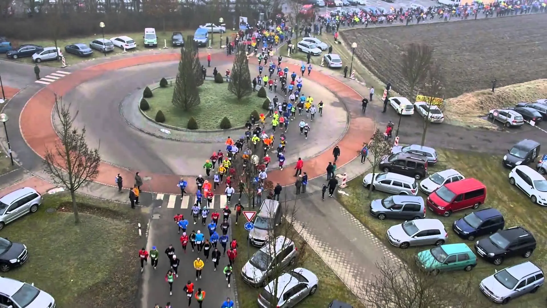 The image shows a road race event, with a large number of participants running on