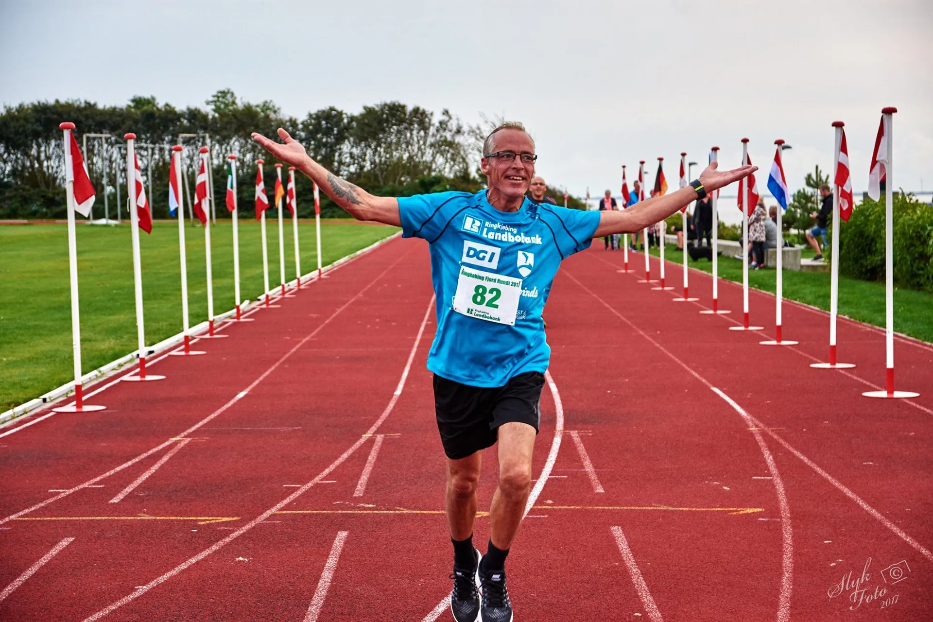 The image shows a man running on a track who appears to be finishing a race