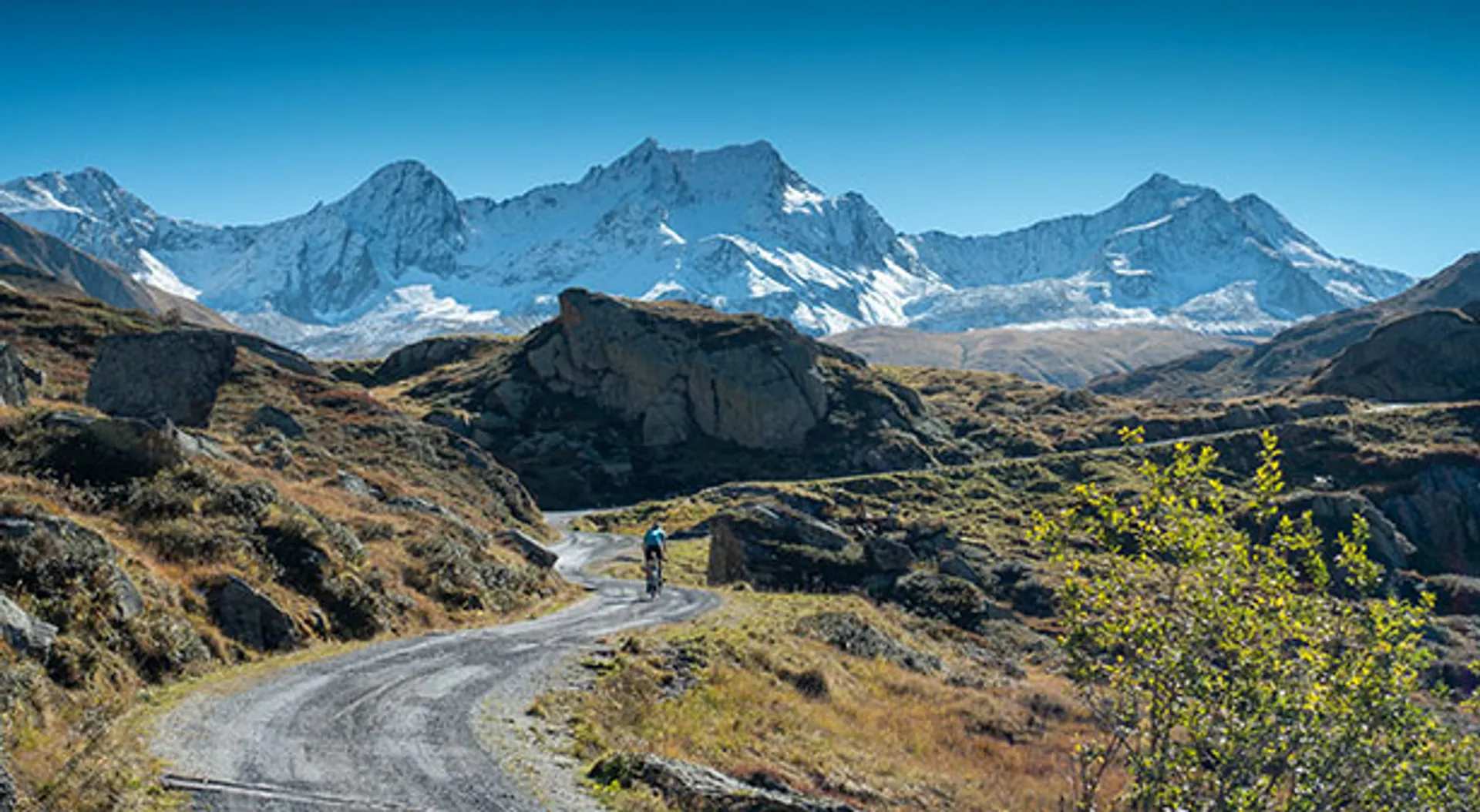 The image shows a scenic view of a mountain landscape under a clear blue sky.