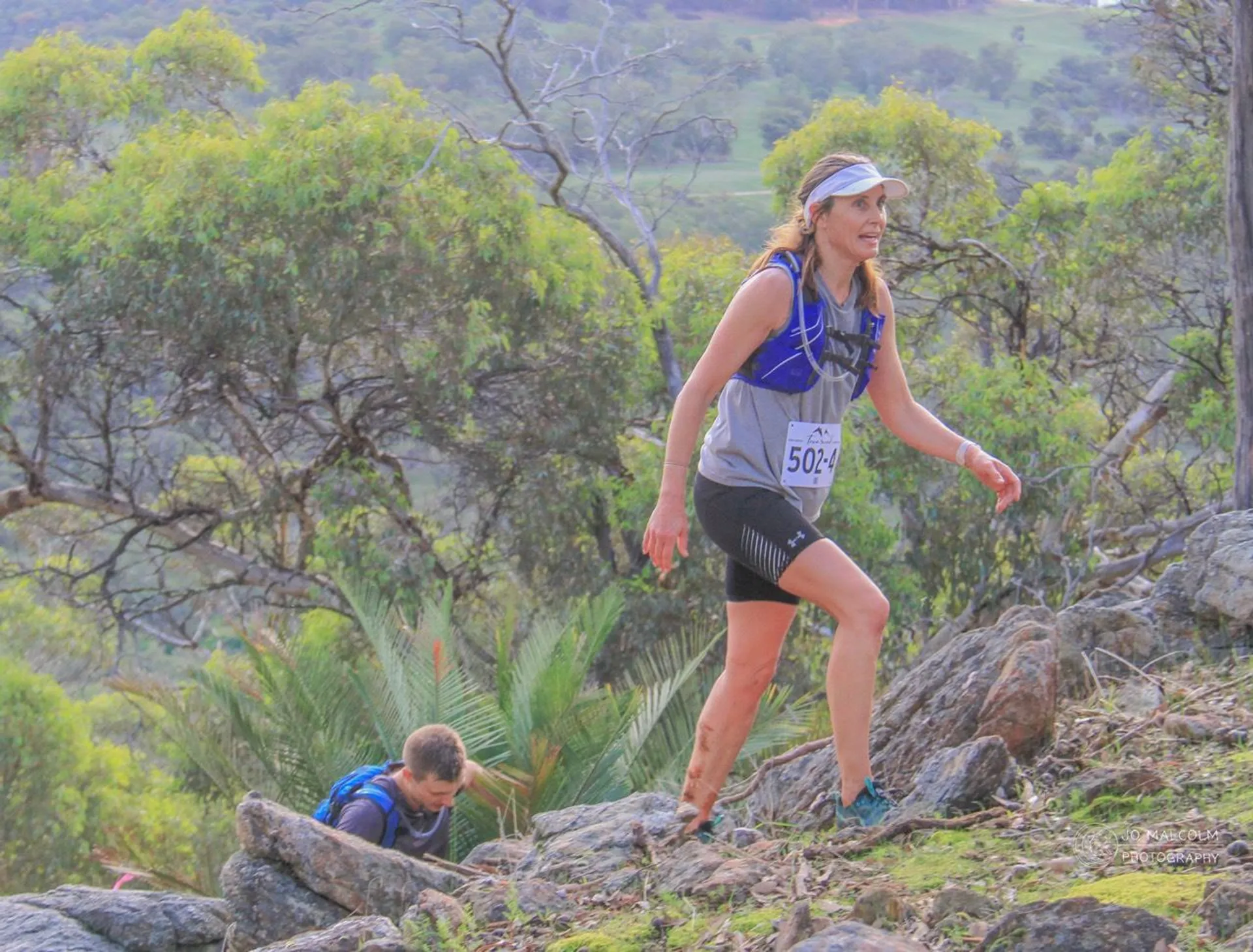 The image features two people participating in what appears to be a trail run or outdoor