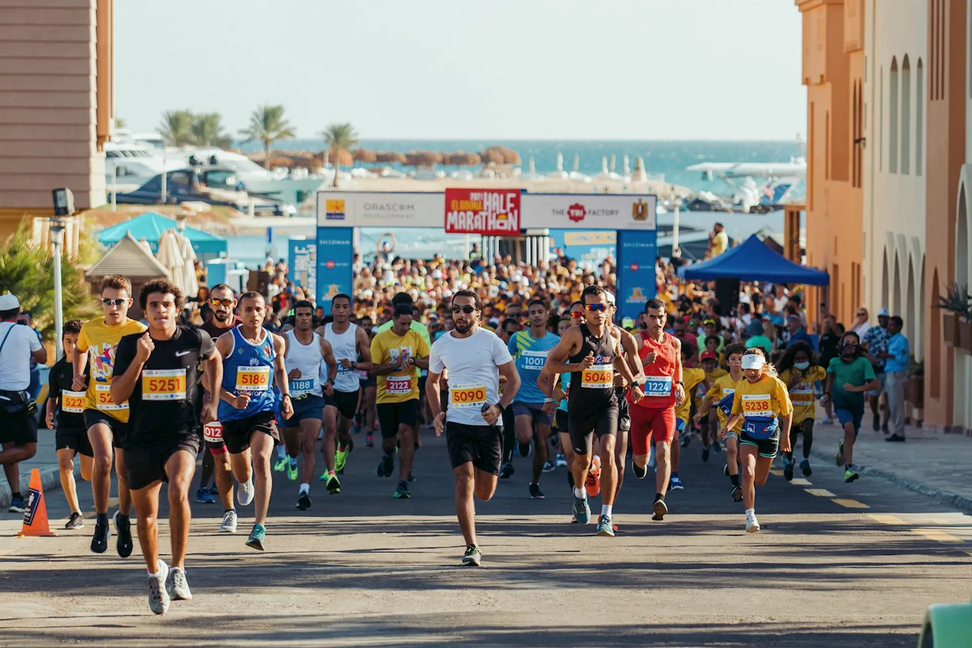 The image shows a group of runners participating in a road race, possibly a marathon