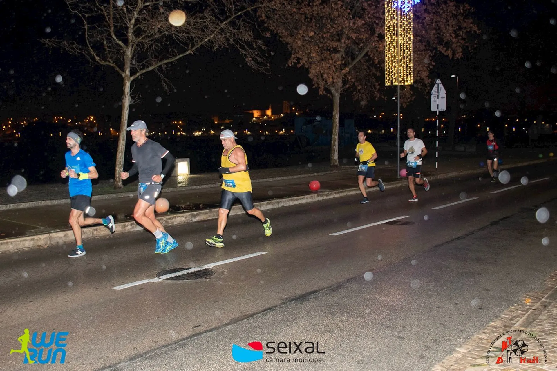 The image depicts a group of individuals participating in a nighttime running event. They are