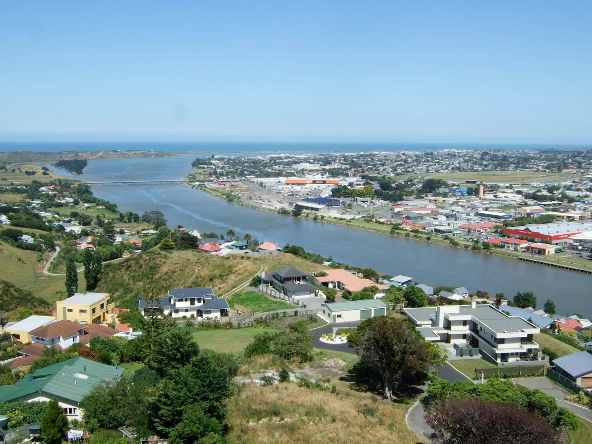 The image shows an aerial view of a coastal town or city. In the foreground
