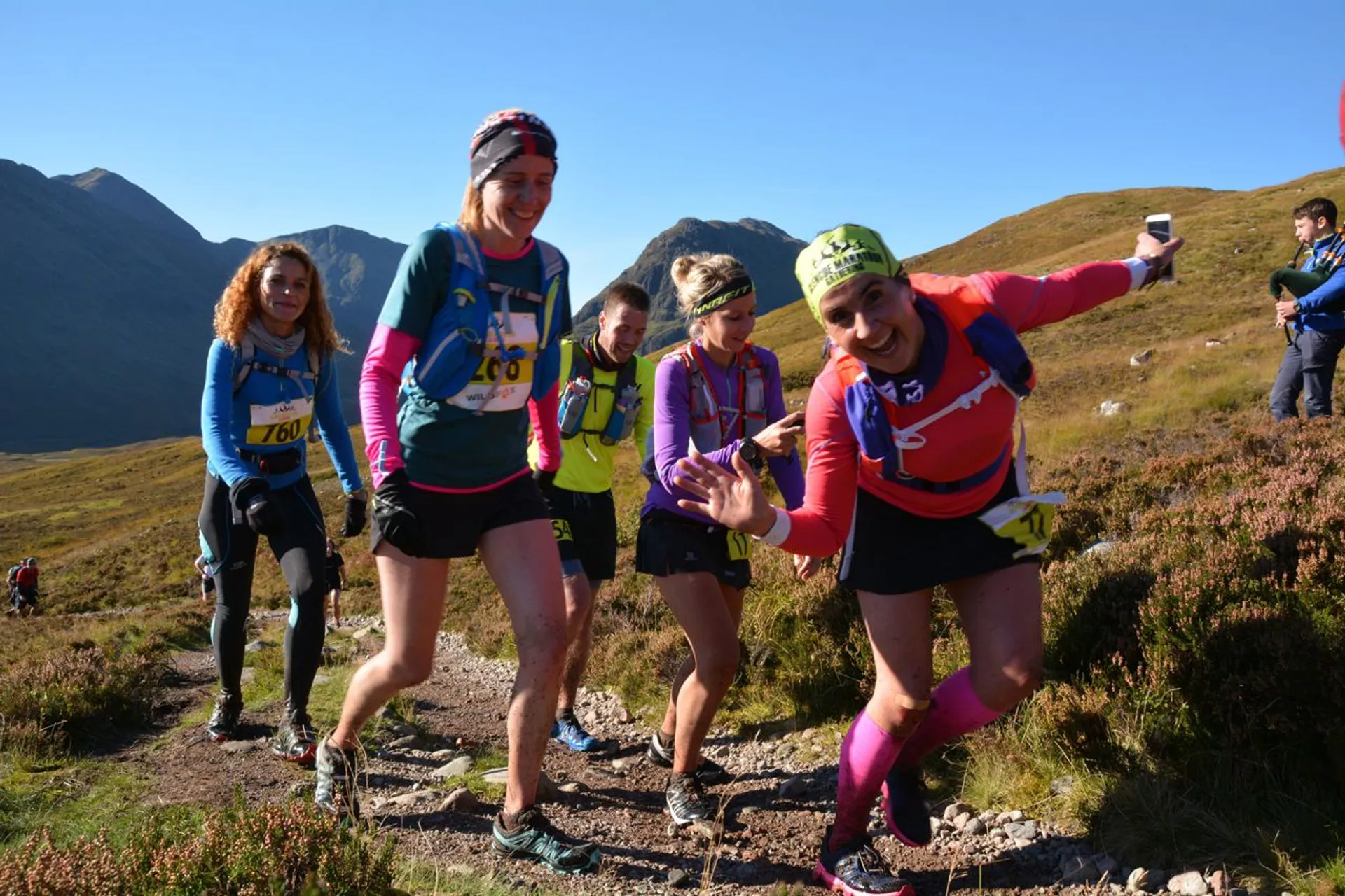 The image shows a group of people participating in a trail running event or race.