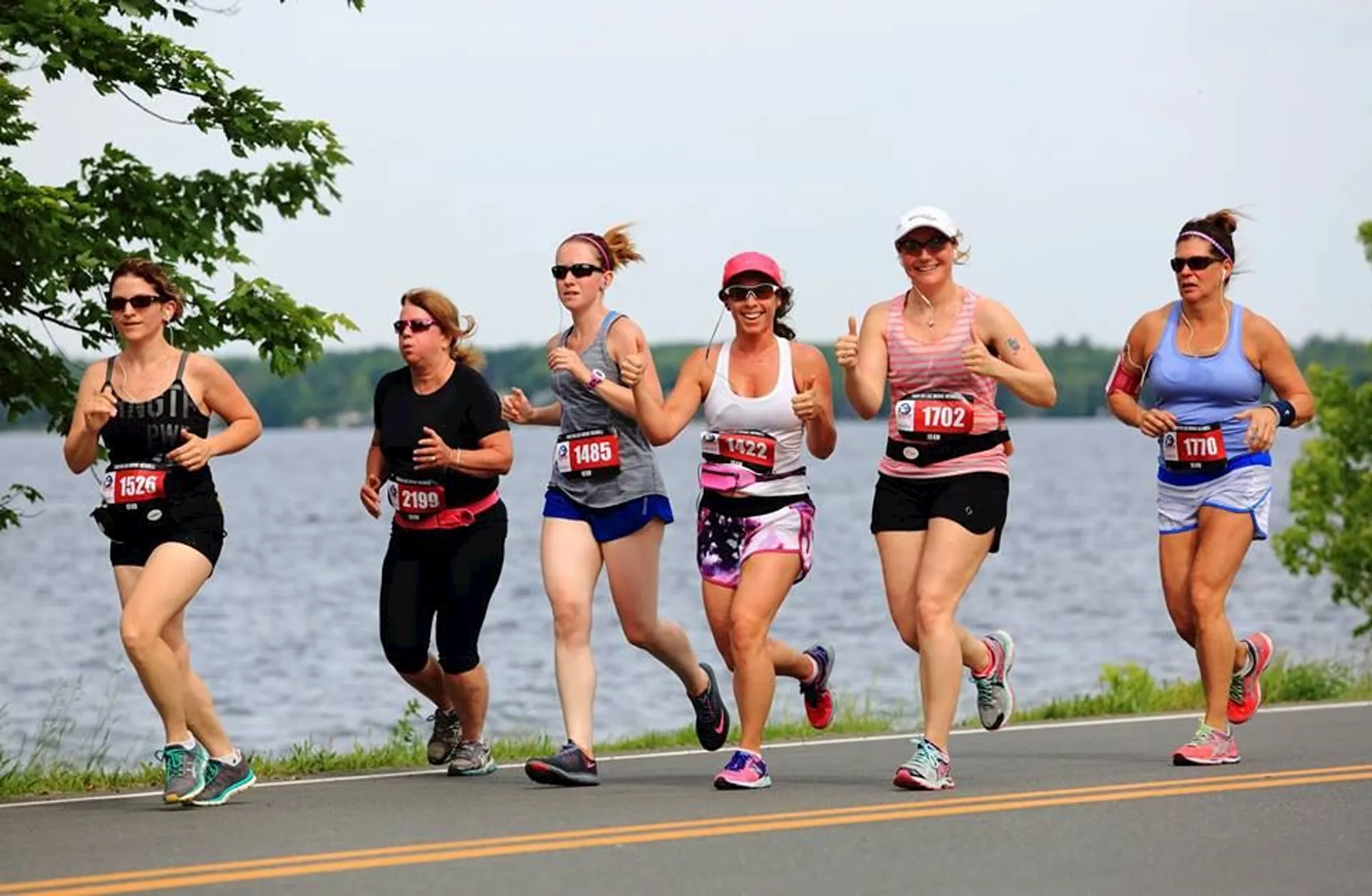 The image shows a group of female runners participating in a road race. They appear