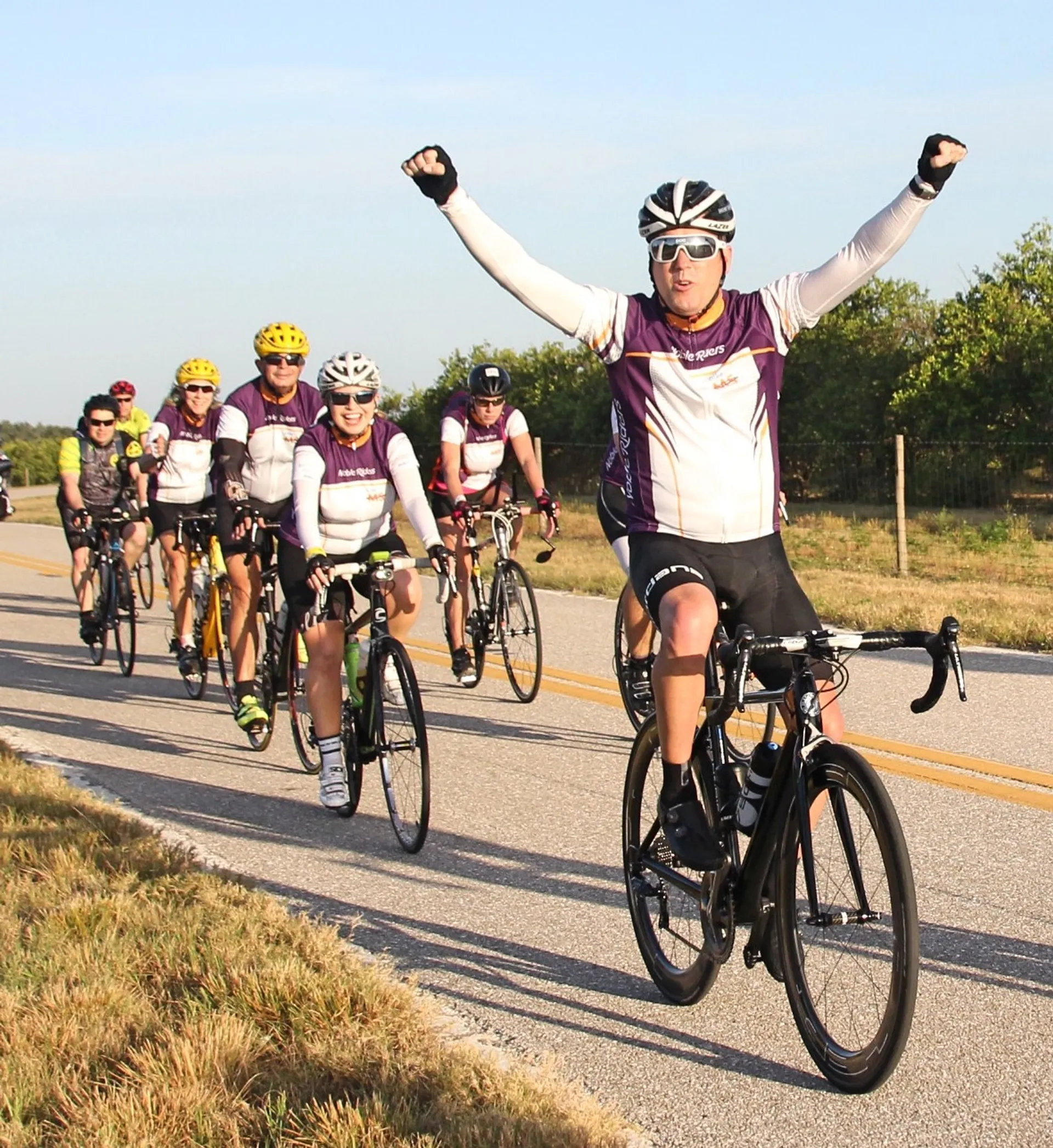 This image features a group of bicyclists on a road. The person at