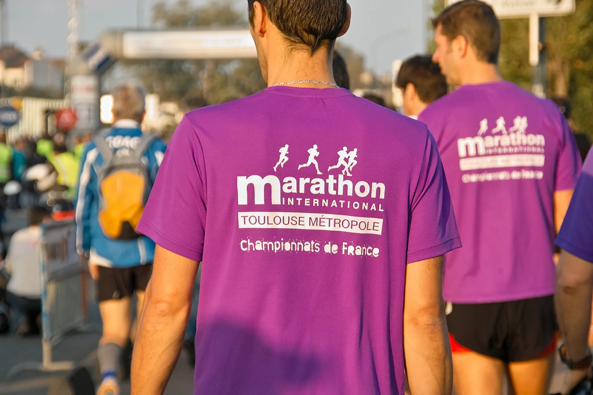 The image shows a group of people at an event, most likely a marathon or