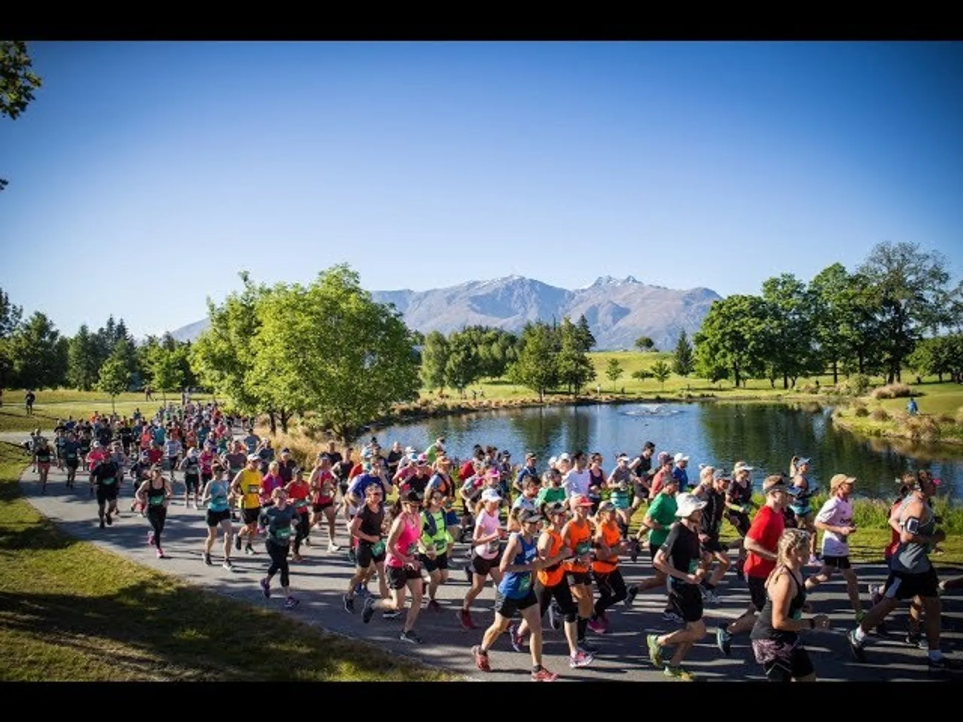 The image shows a group of people participating in a running event, with many runners