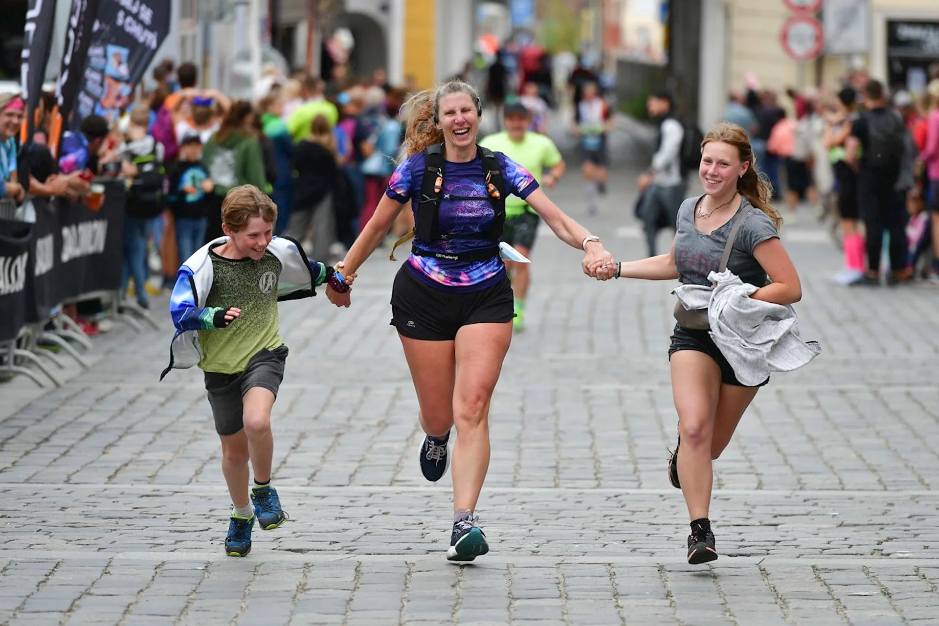 The image shows three individuals running through what appears to be a city street or a