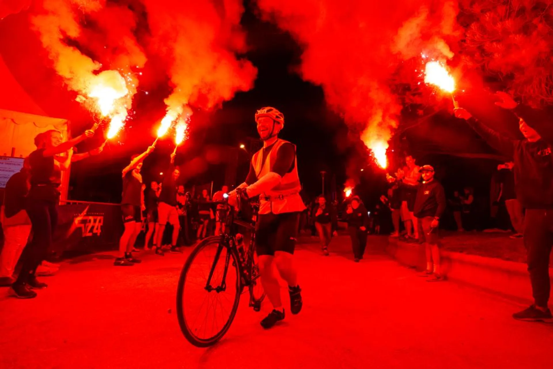 The image shows a night-time scene where a cyclist is in the center, seemingly