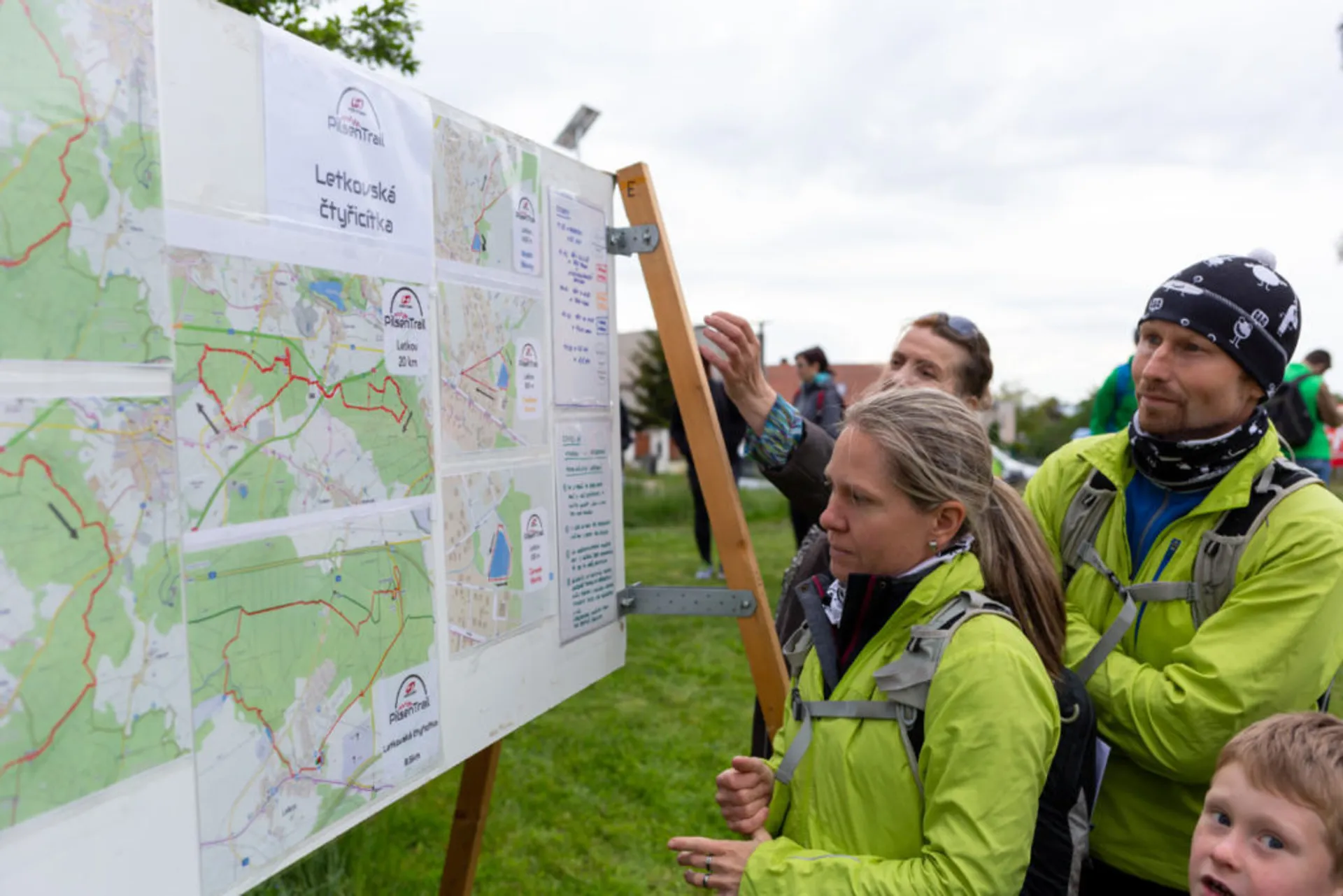 The image shows a group of people looking at a board with what appears to be