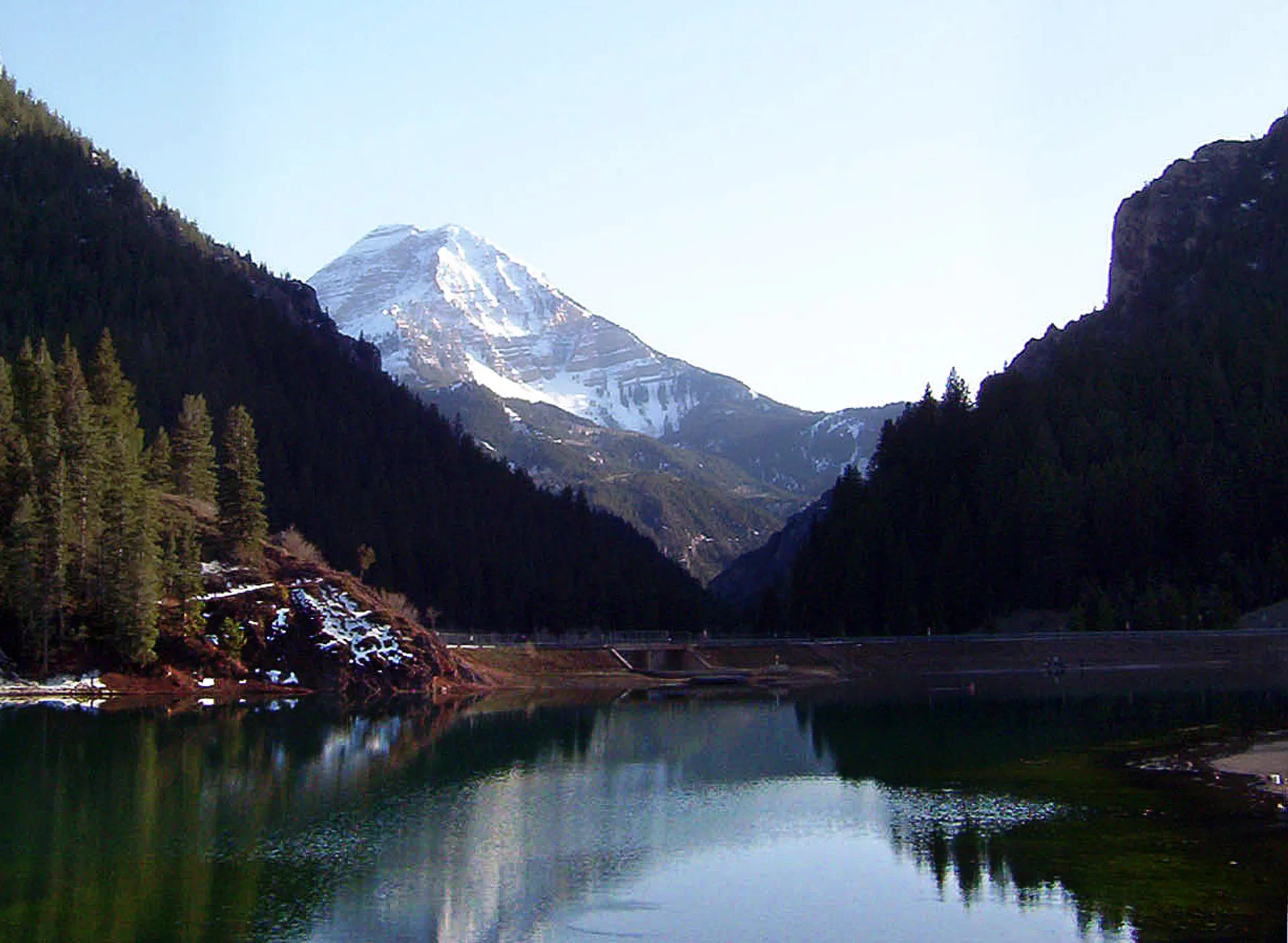 The image depicts a serene mountain landscape. There's a body of water, likely