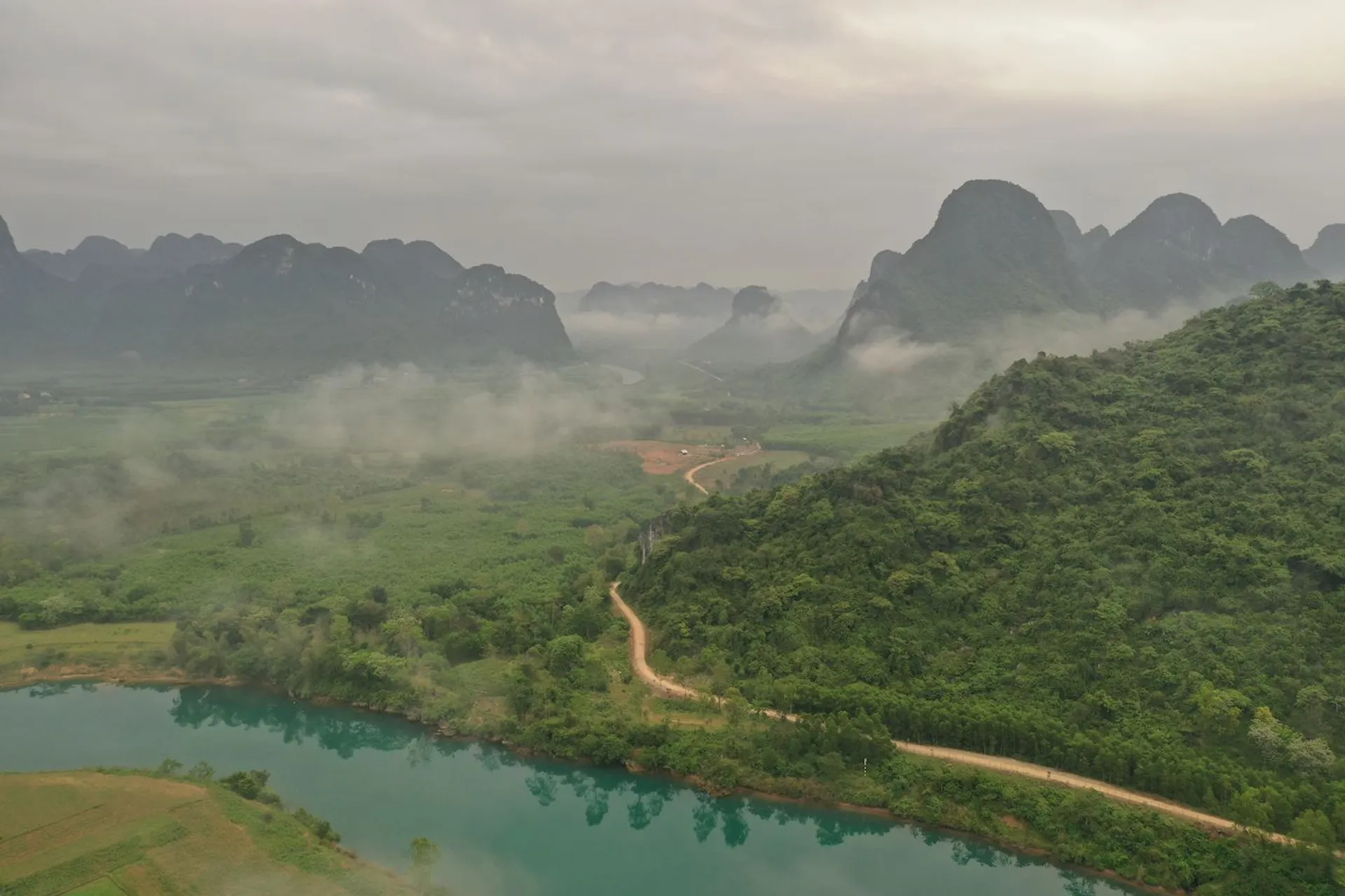 The image shows a scenic landscape that includes a winding river or lake with a distinctive